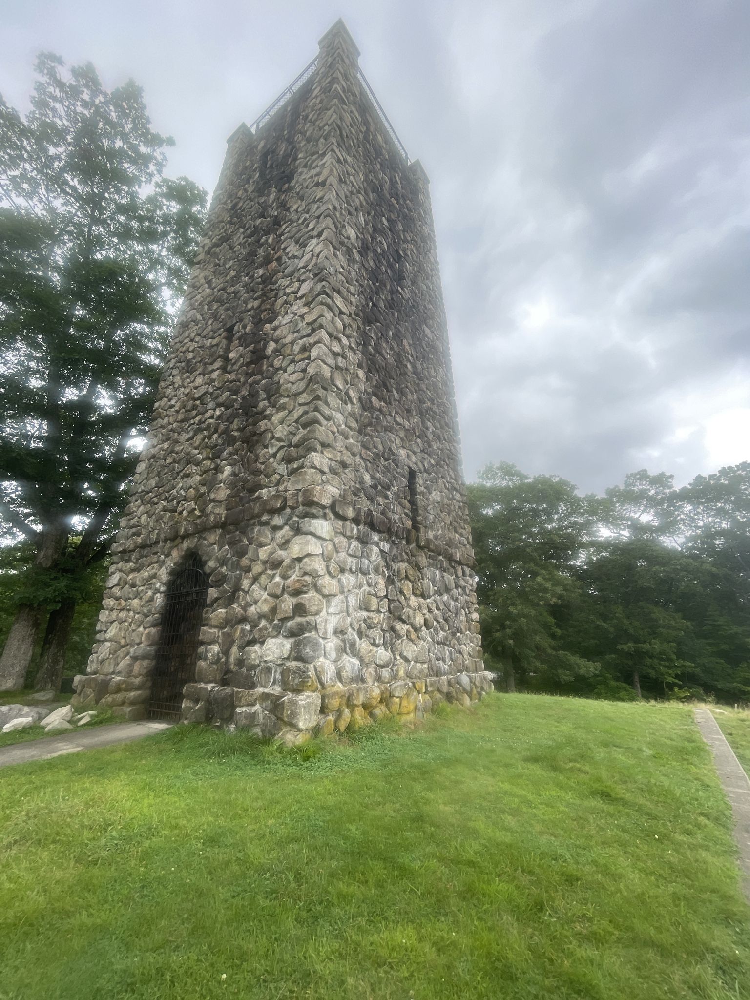 Tall stone tower on a grassy hill under an overcast sky. - H.H. Hale Memorial Tower – D W Field Park loop from Boston Medical Center – South