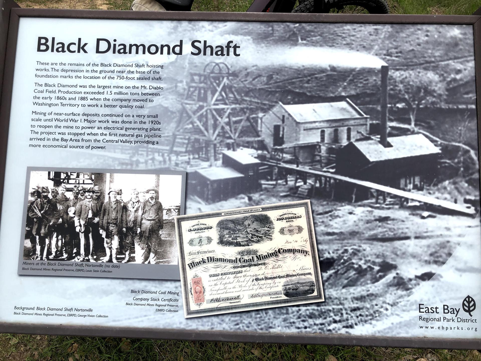 Informational sign displaying historical black and white mining photos and text.