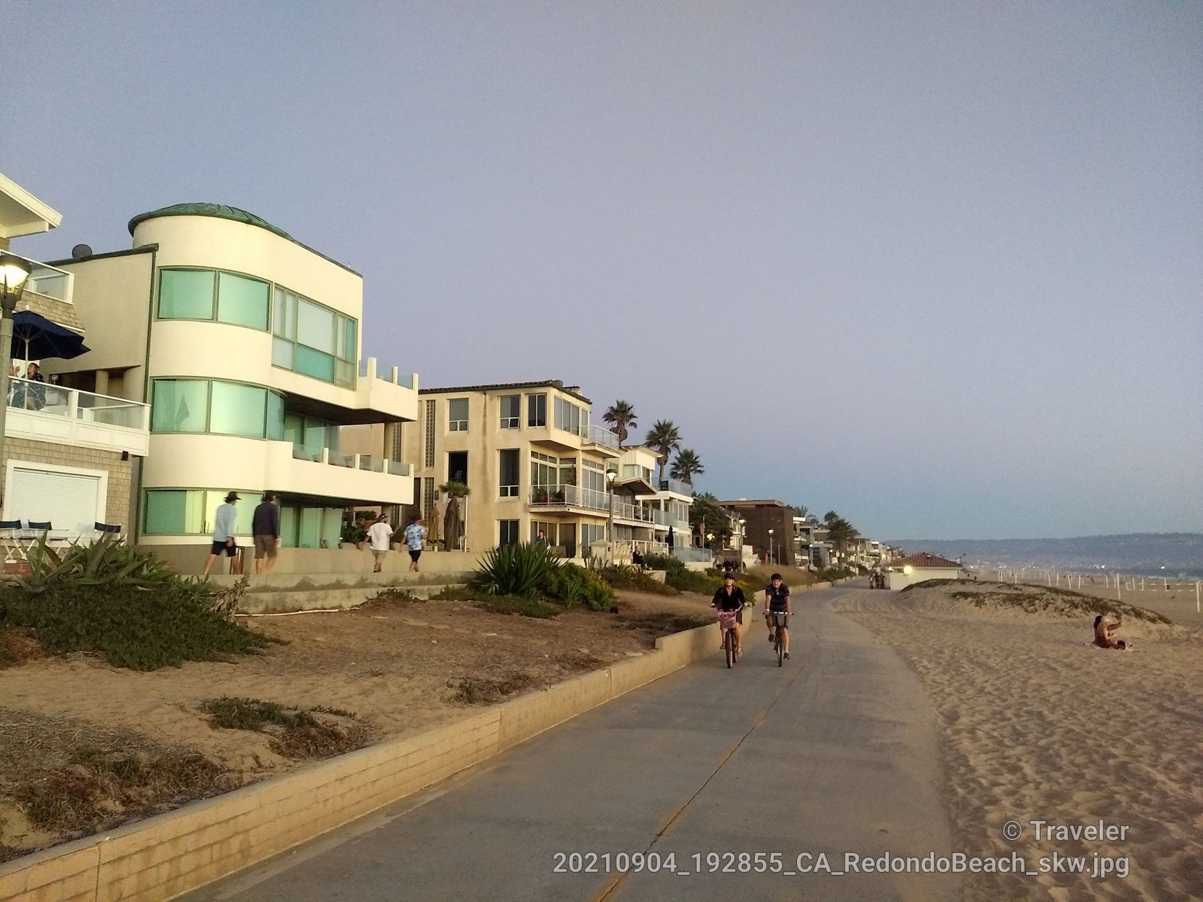 Beachfront houses, people walking and cycling on a path at dusk. - Marvin Braude and Ballona Creek Bike Path Loop
