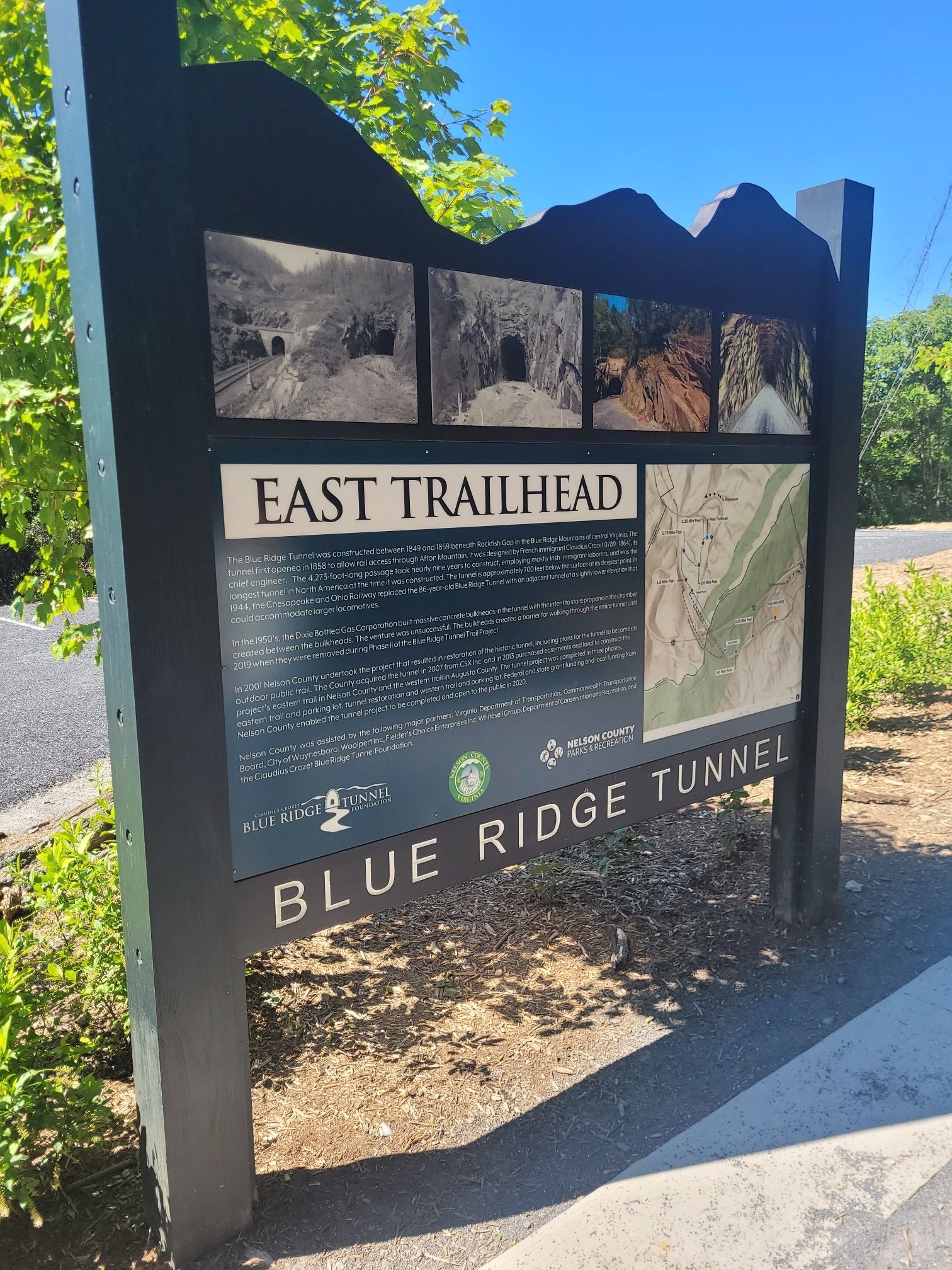 A large outdoor informational sign with text and images on a sunny day. - Blue Ridge Tunnel Trail