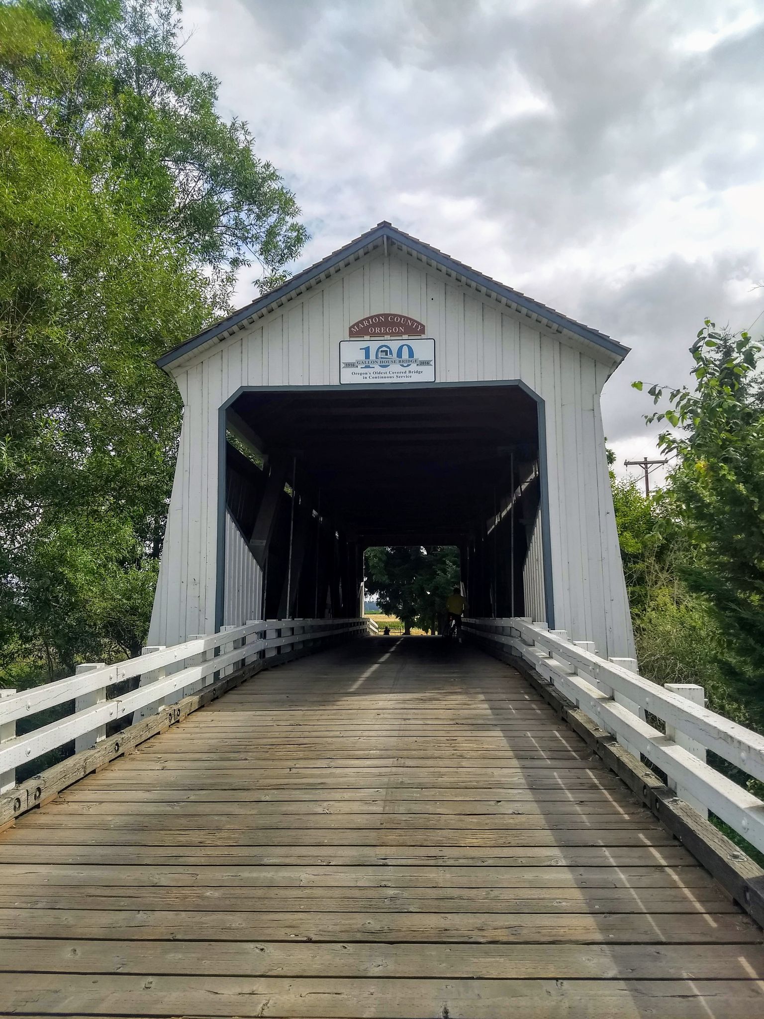 Wooden covered bridge with white railings under a cloudy sky. - Keizer to Gallon House Covered Bridge loop