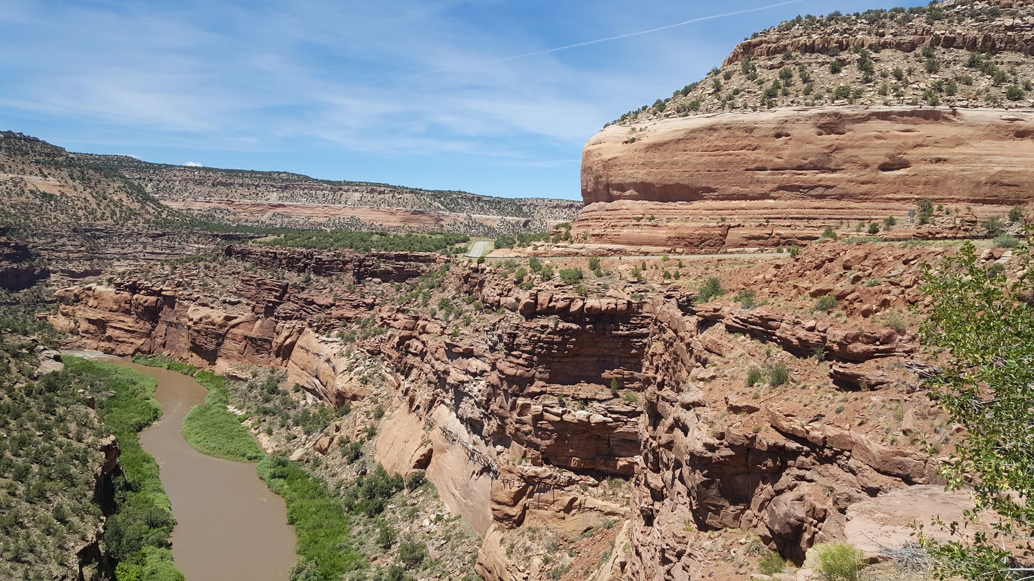 A wide, rocky canyon with a winding river under a bright blue sky. - Hanging Flume via Tabeguache Preserve