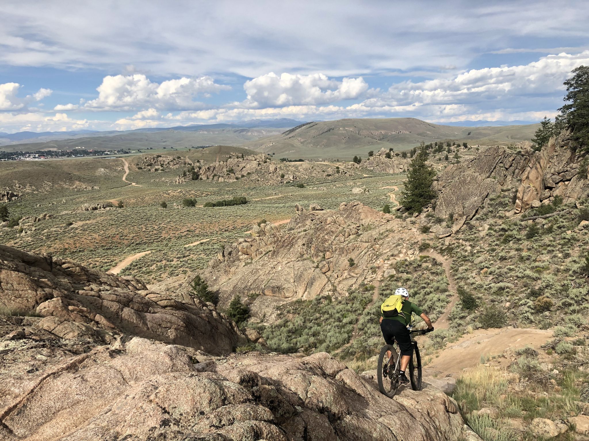 A mountain biker descends a steep, rocky trail overlooking a vast valley. - Rocky Ridge Trail – Free Fall loop from Hartman Rocks