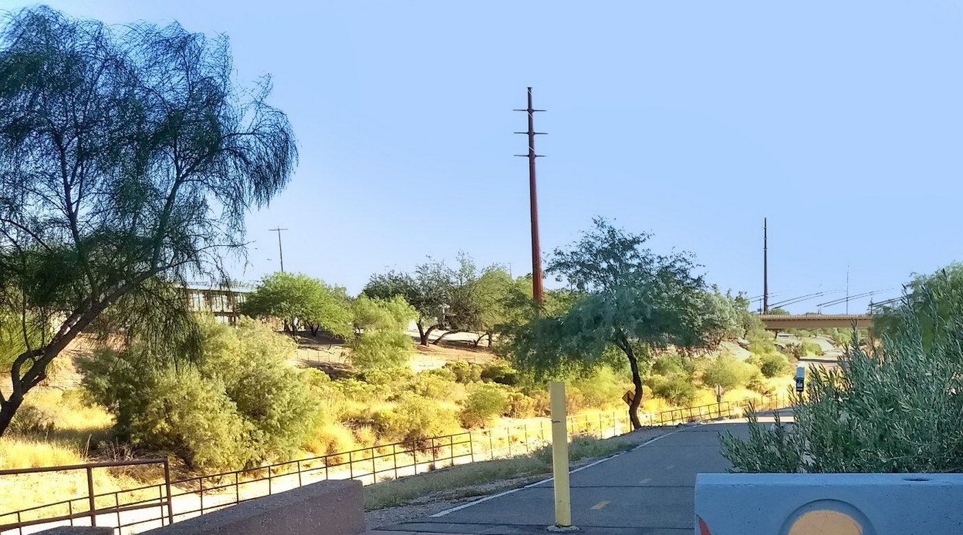 Paved path next to a dry, brushy hillside with a utility pole under a clear sky. - Juan Bautista de Anza Trail – Garden of Gethsemane Park loop from Dakota Wash