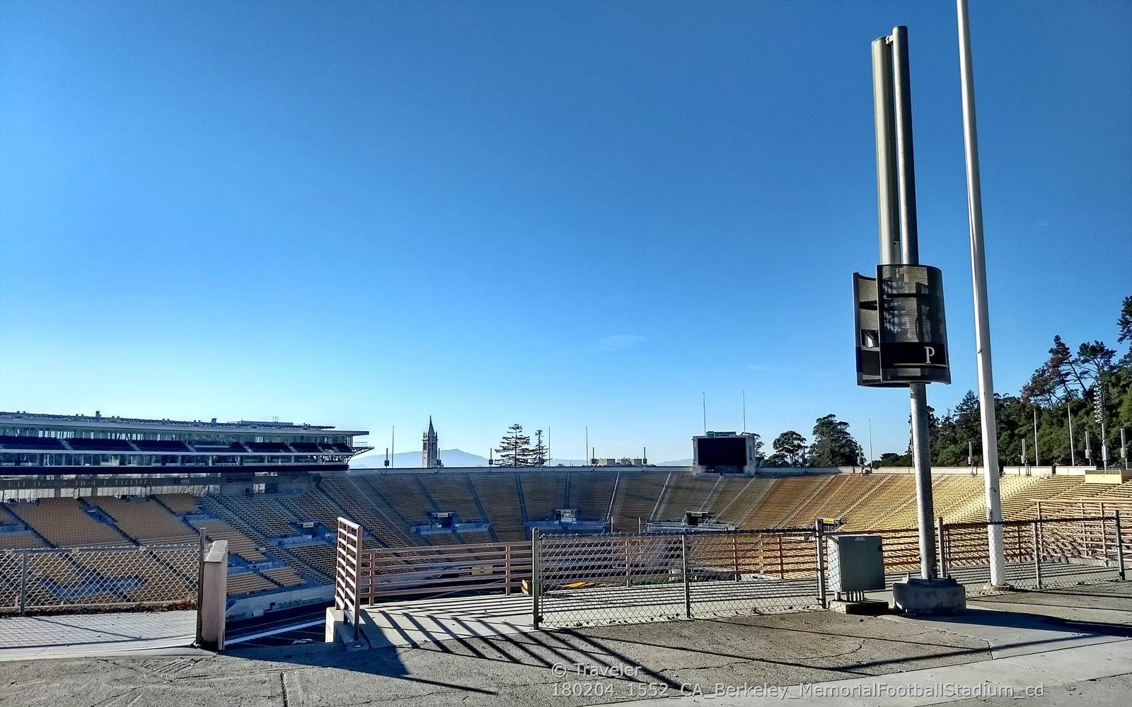 Empty stadium bleachers and a scoreboard under a clear blue sky. - California Memorial Stadium loop from Berkeley