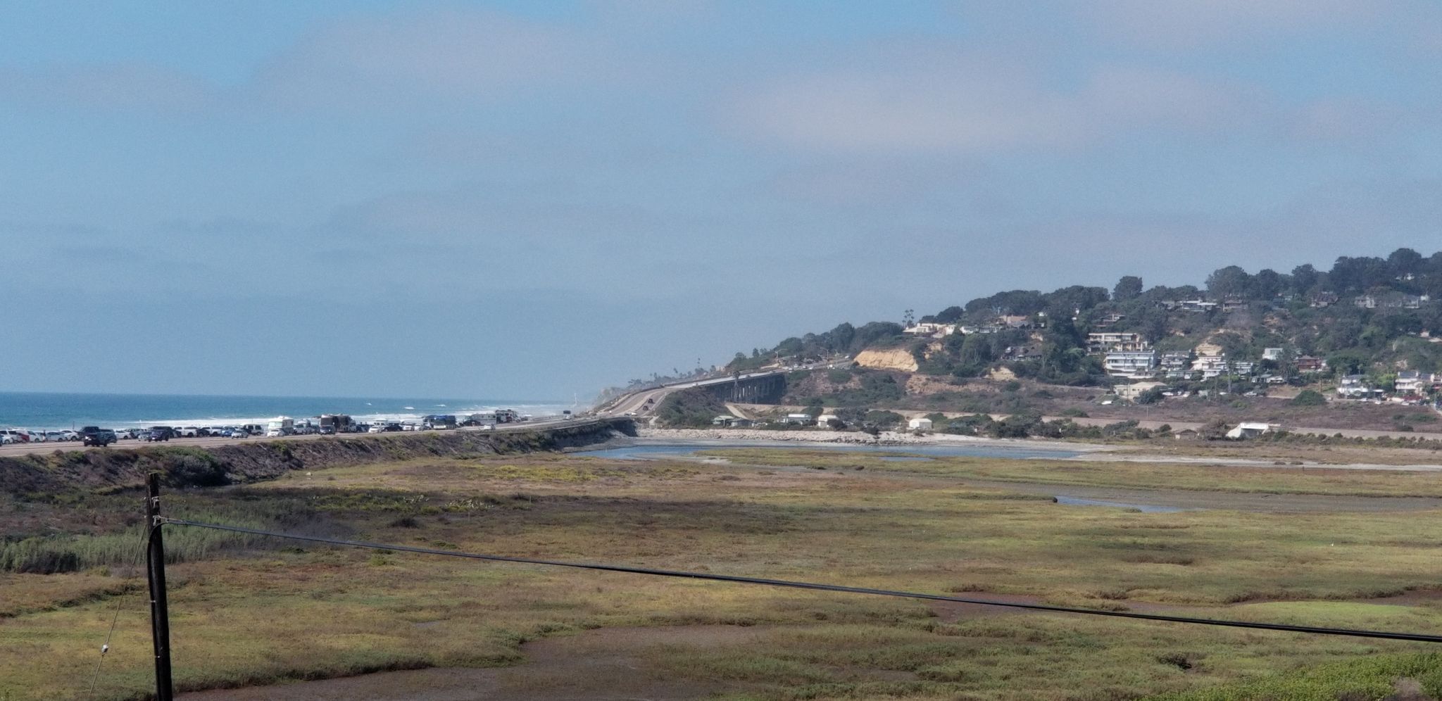 Sunny coastal view with marshland, distant ocean, highway, and hillside homes. - California Mission Trail - stage 01 Mission San Diego de Alcalá (1769) to Mission San Luis Rey (1798)