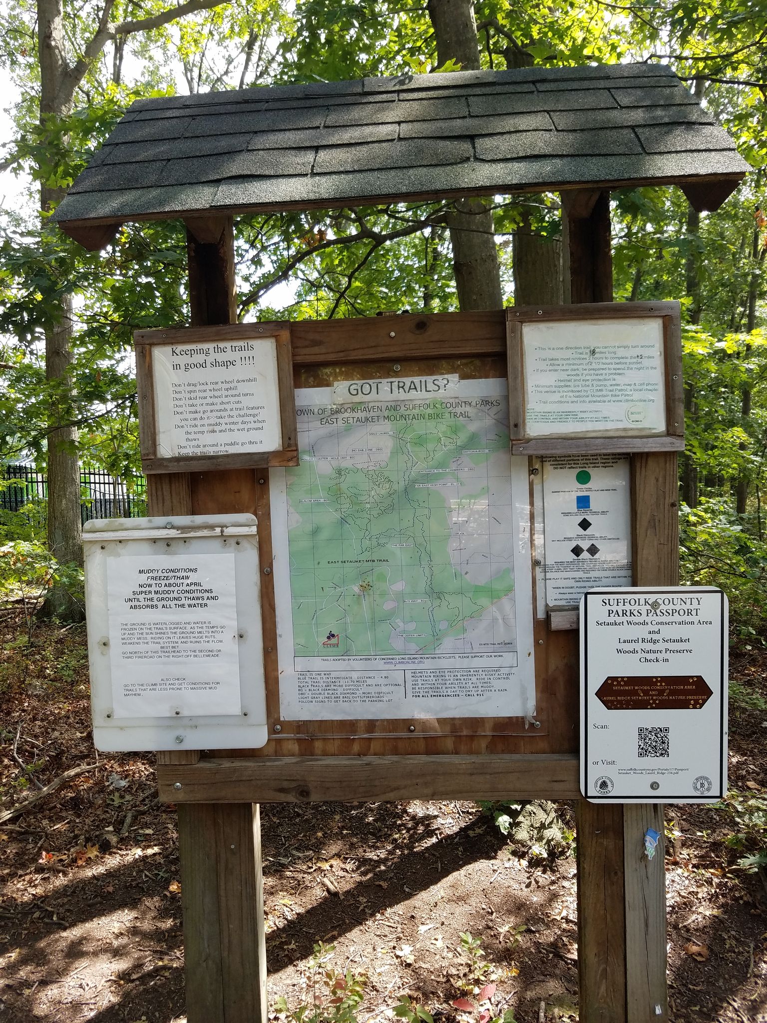 Wooden trail information board with map and signs under trees on a sunny day. - Laurel Ridge Trails loop from Stony Brook
