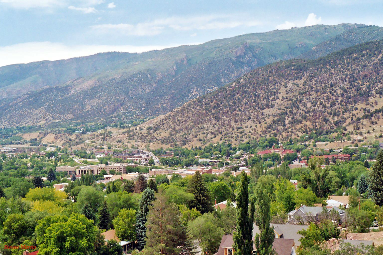 Aerial view of a town surrounded by green, tree-covered mountains. - Rio Grande Trail and Cattle Creek Loop