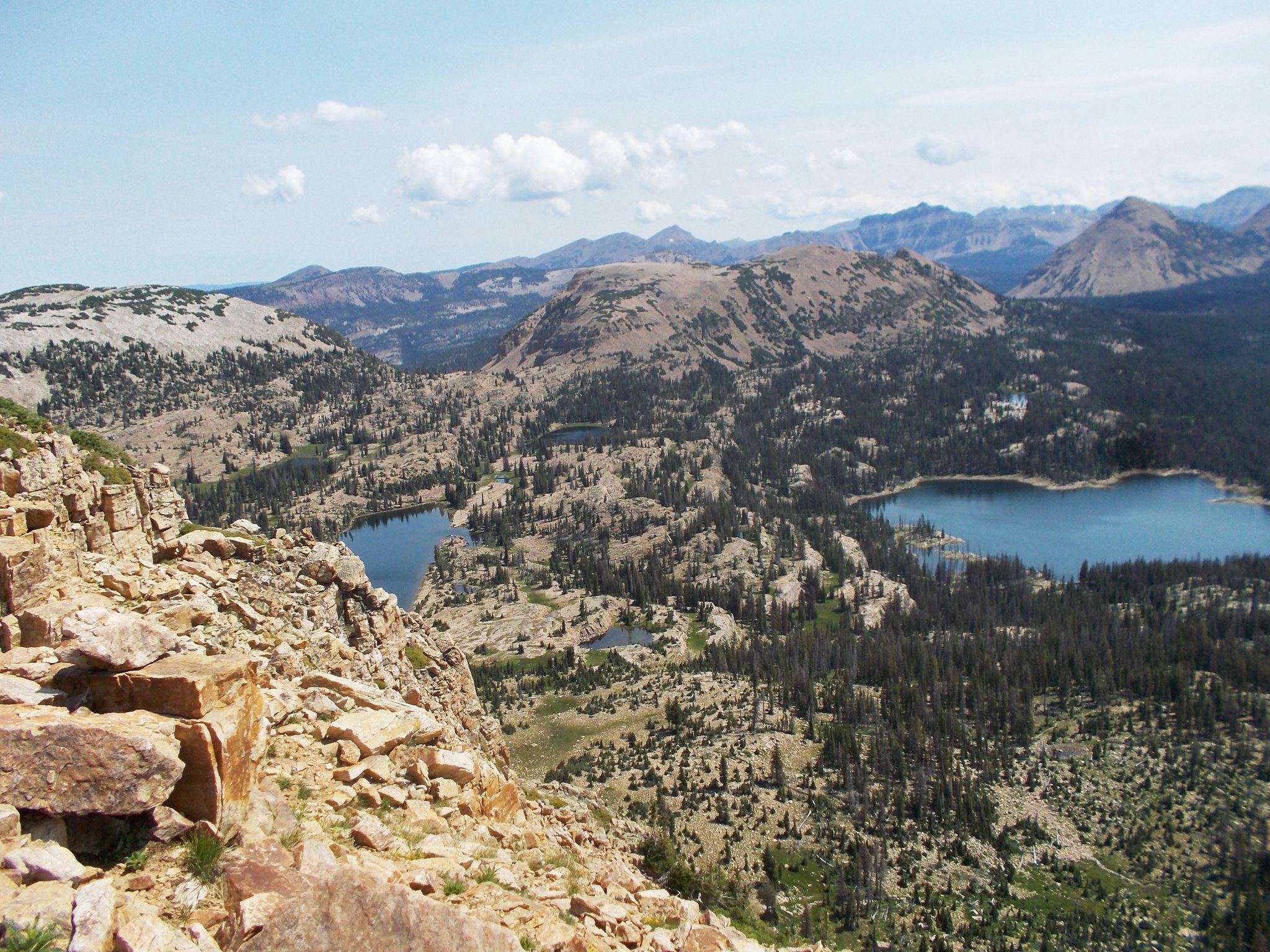Expansive mountain landscape with two blue lakes, rocky terrain, and forests. - Ibantik Lake Trail