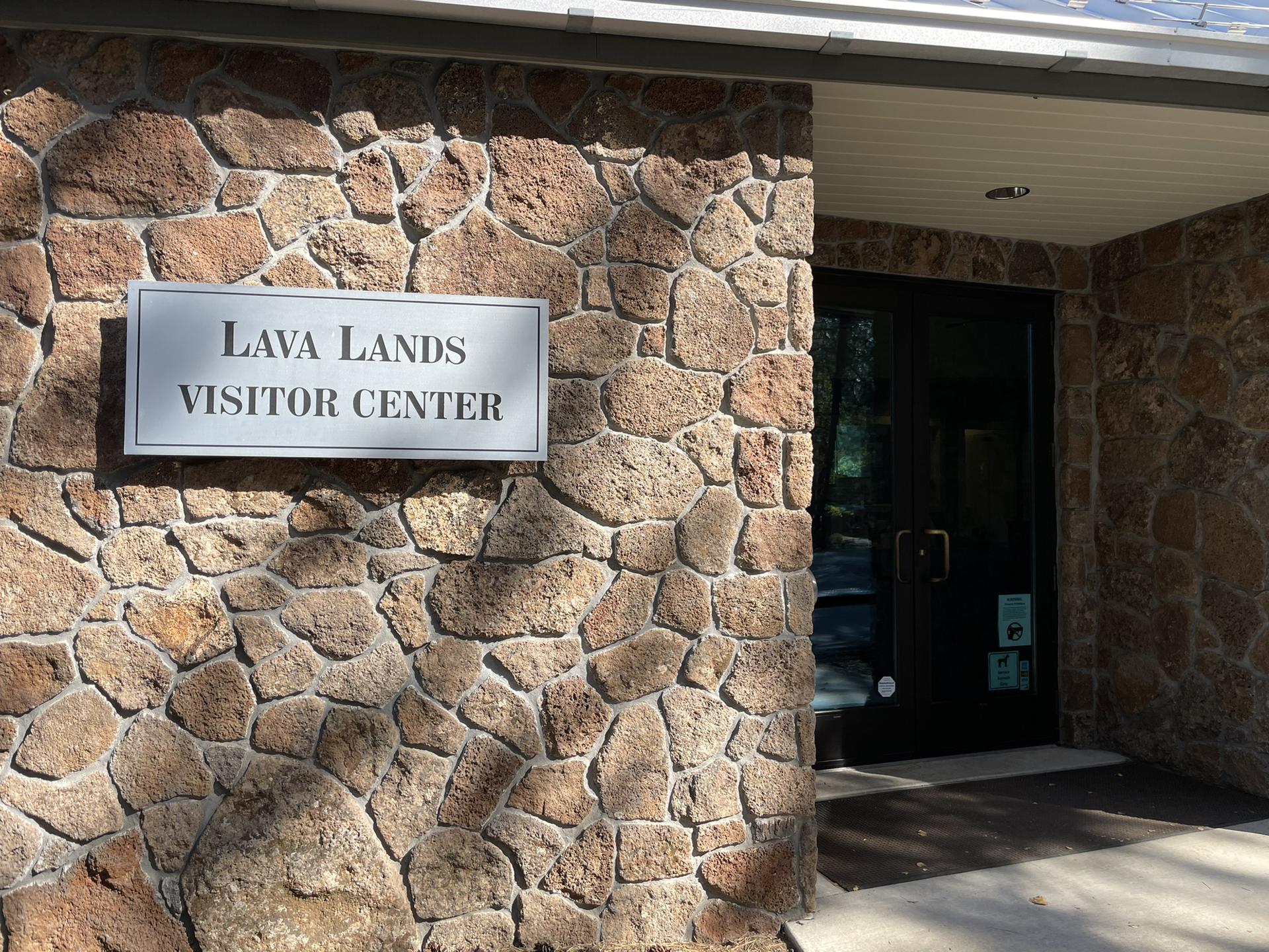 Close-up of a stone building with a "Lava Lands Visitor Center" sign.