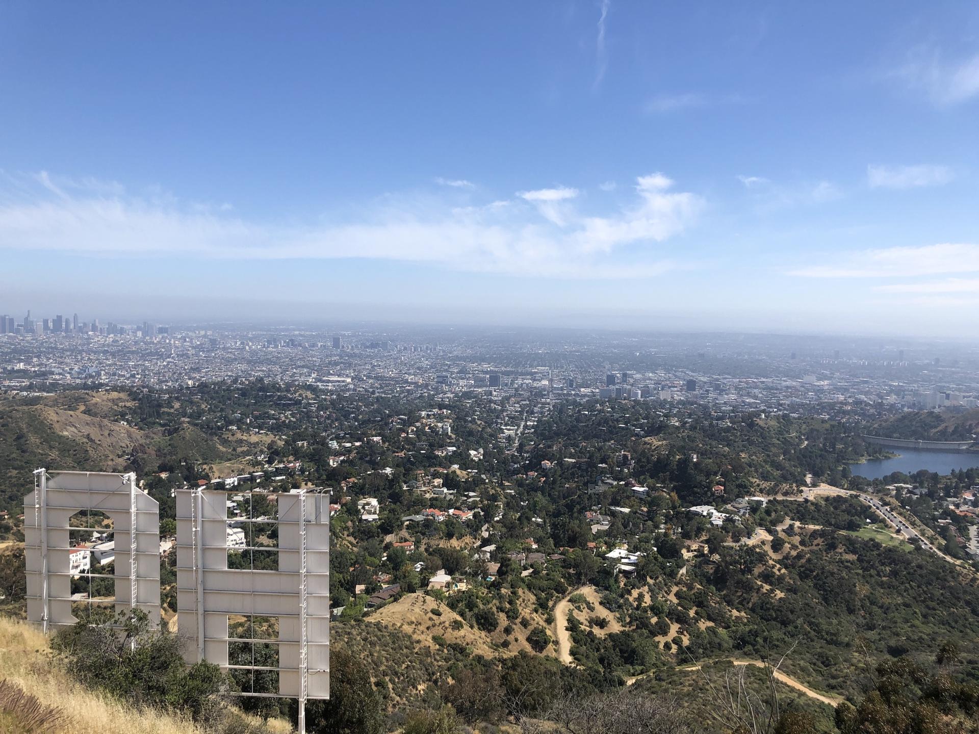 Large white letters on a hill overlooking a vast, hazy city.