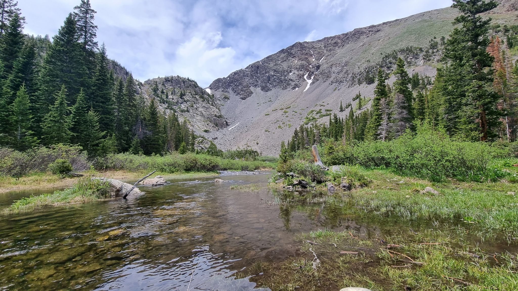 Clear stream flowing through a green valley with rocky mountains. - Spruce Creek Trail to Mohawk Lakes Trail