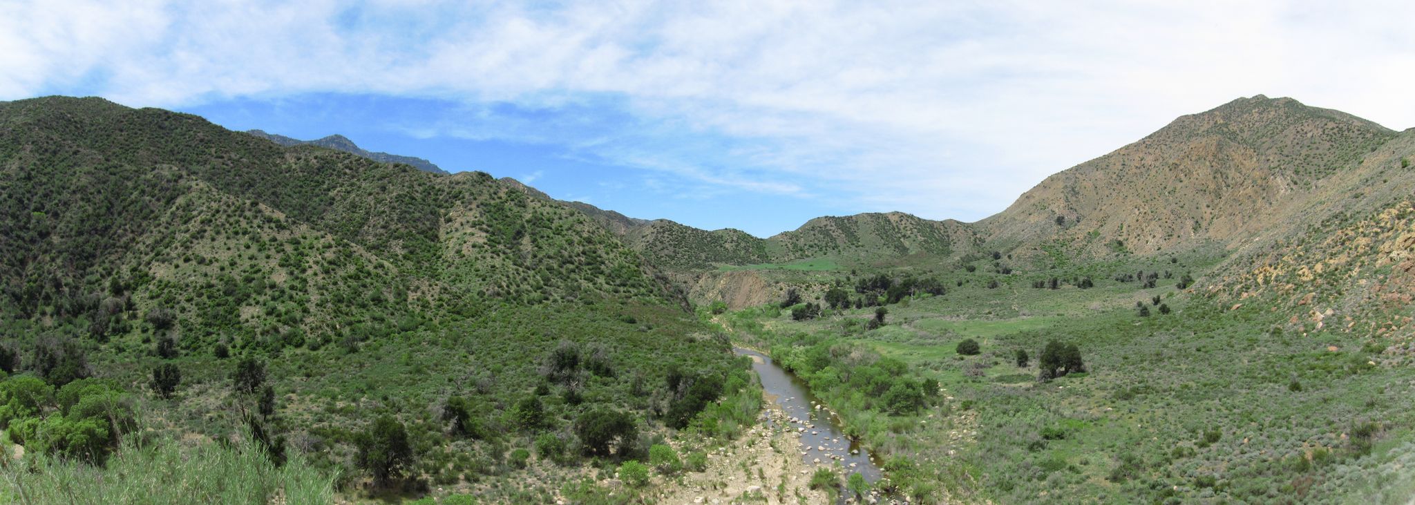 Panoramic view of a green mountain valley with a road under a partly cloudy sky. - Sespe River Trail to Willett Hot Springs