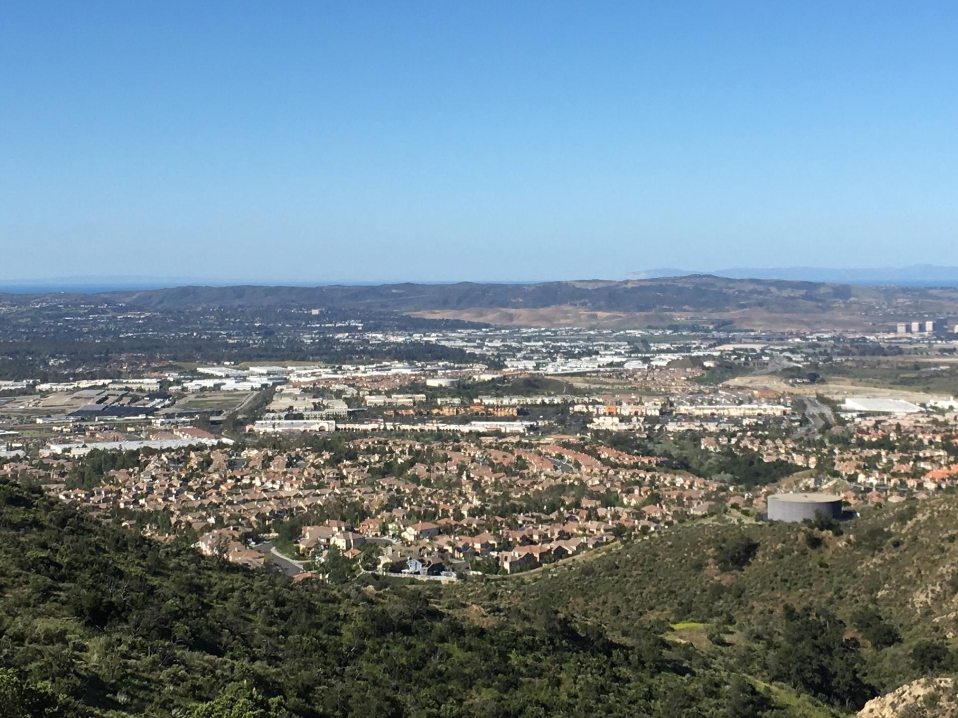 Panoramic view of a sprawling city and distant hills under a clear sky.
