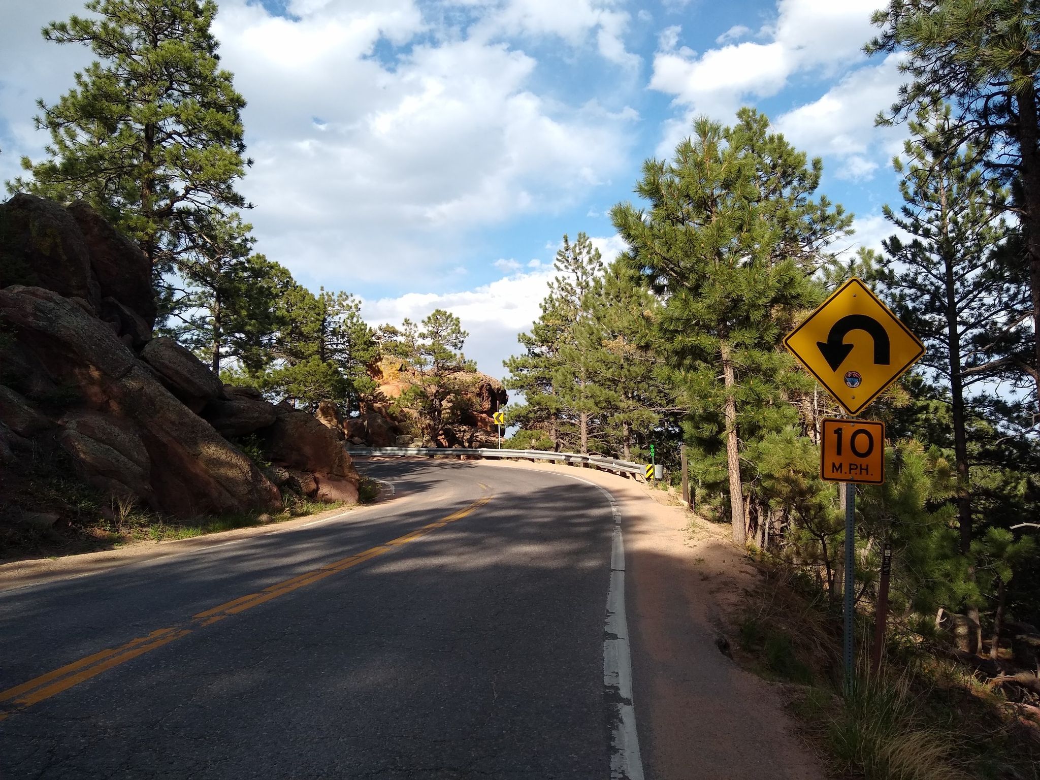 Winding mountain road with a U-turn sign under a partly cloudy sky. - Flagstaff Mountain to Gross Reservoir