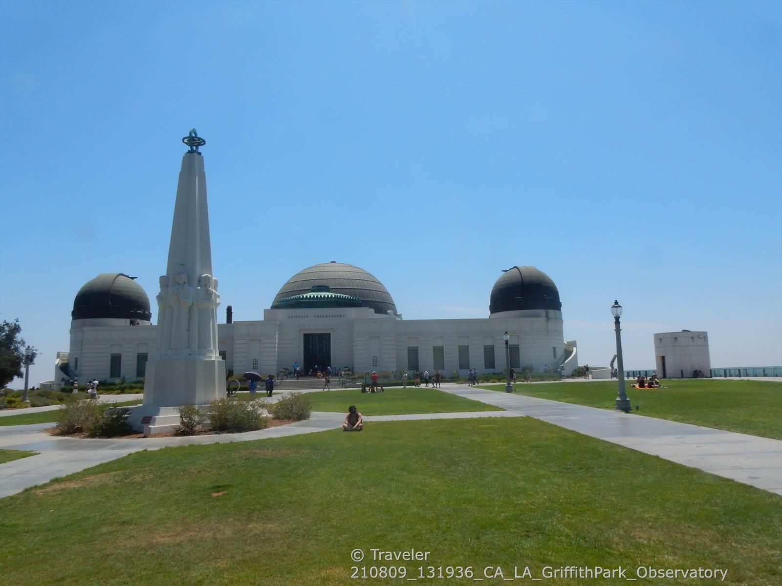 Large white domed building with an obelisk on a sunny day, people walking.