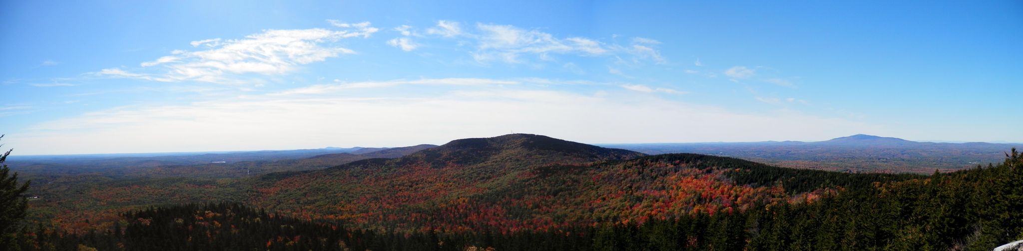 Panoramic view of forested mountains with autumn colors under a clear blue sky. - North Pack Monadnock Mountain loop from Lincoln-Davis Memorial Forest
