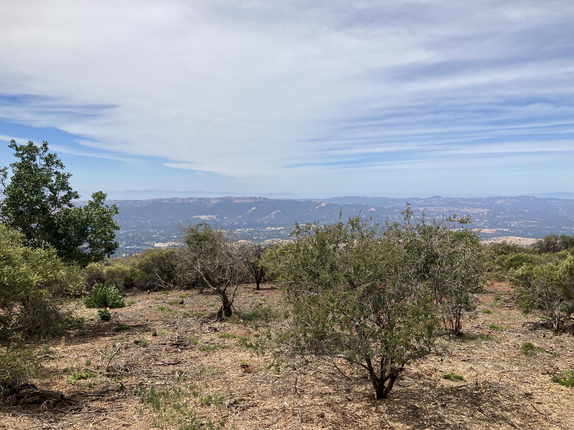 Panoramic view of distant hazy hills under a partly cloudy sky.