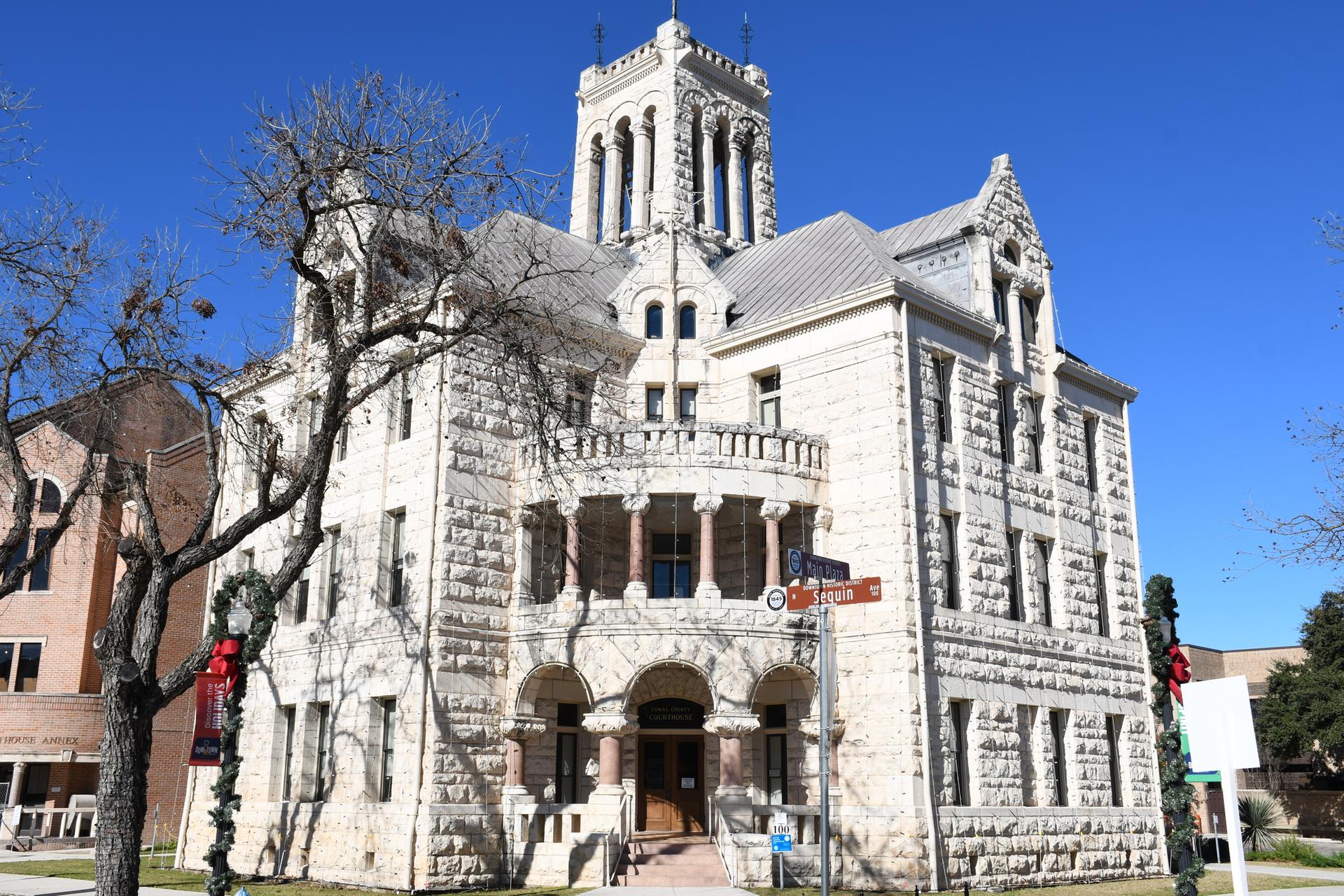 Grand, ornate stone building with a tall tower under a clear blue sky.