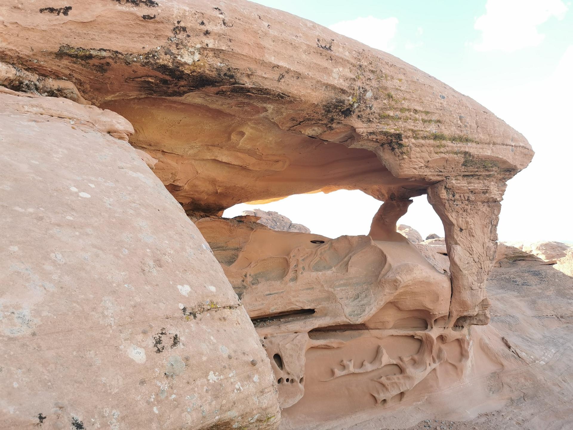 Close-up of a light rock formation with a natural arch and eroded patterns.