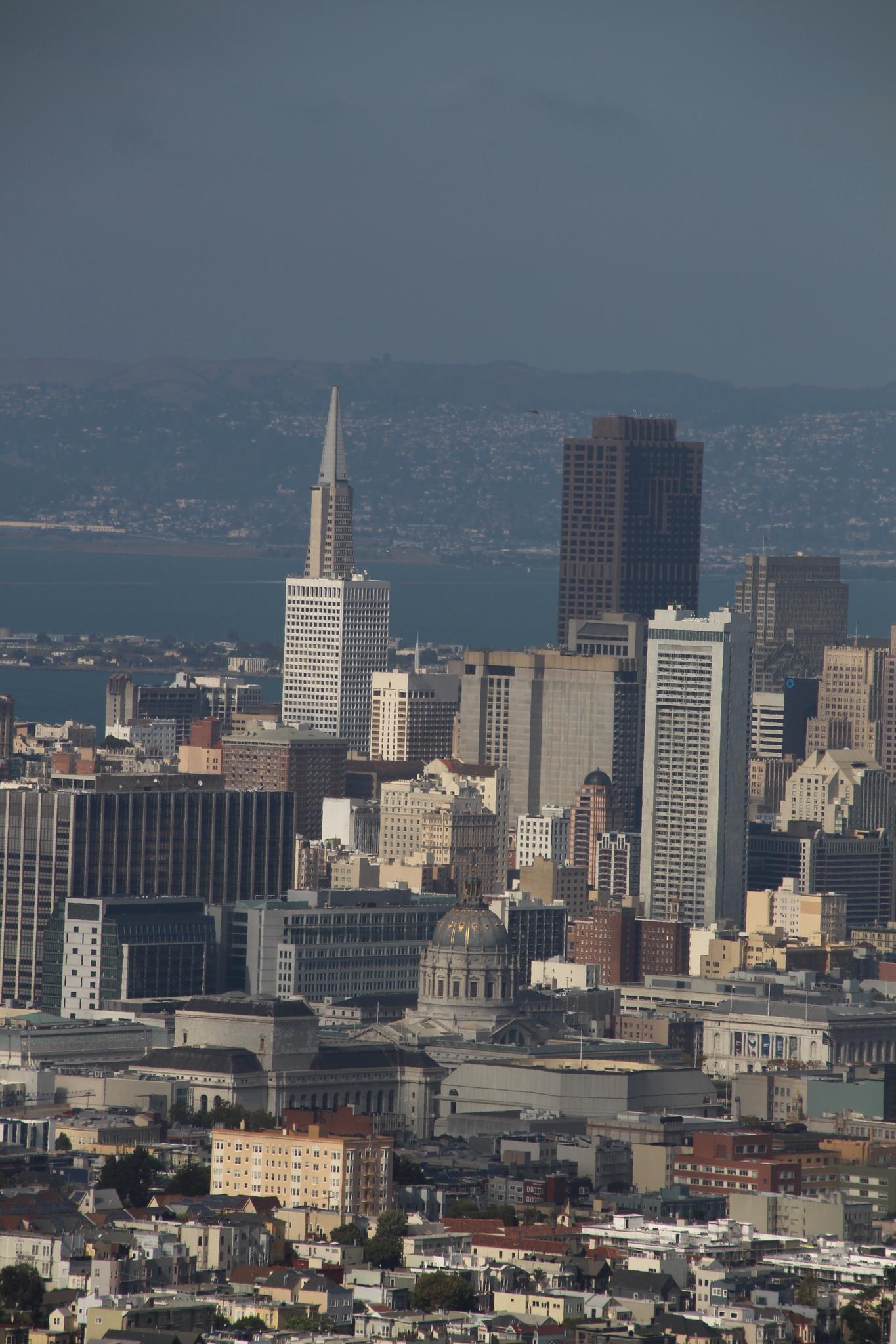 Close-up of city skyscrapers and buildings under a dark sky.