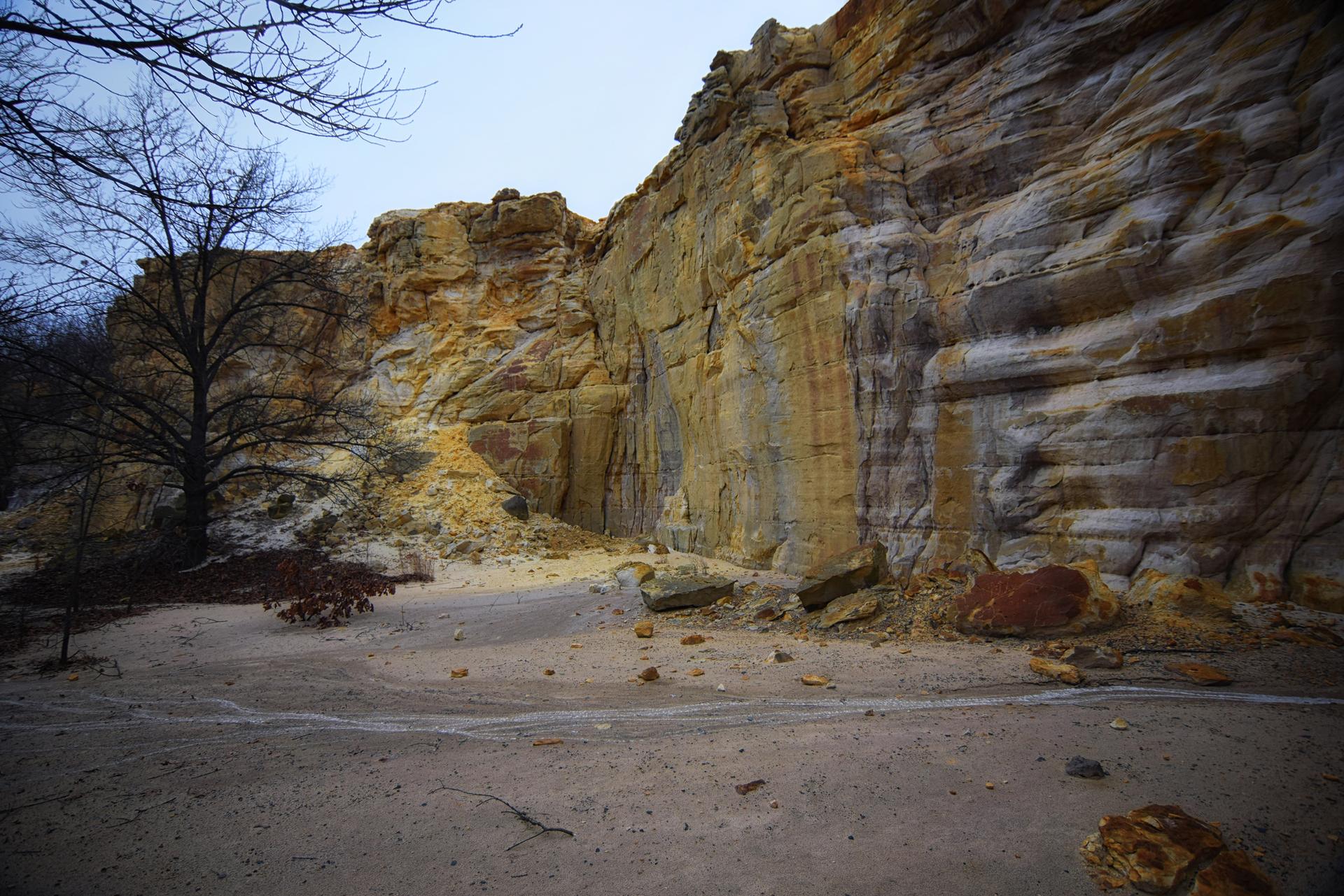 Large, colorful rock formations tower over a sandy, barren landscape.