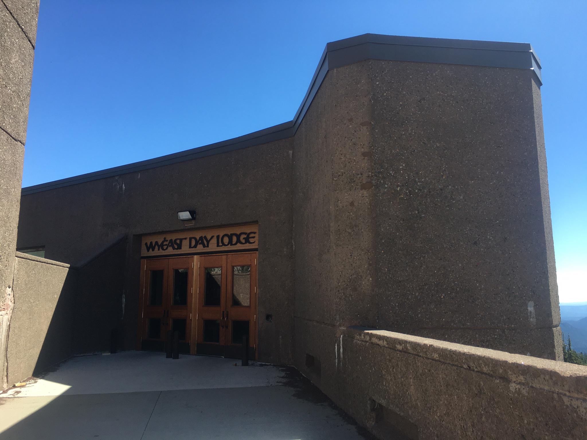 Concrete building entrance with "DAY LODGE" sign under a clear blue sky.