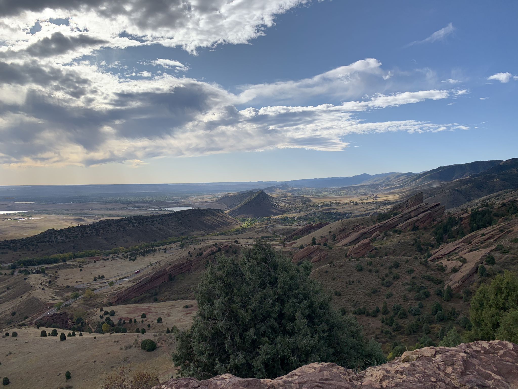 Expansive mountain landscape under a partly cloudy sky, with distant plains. - Red Rocks and Morrison Slide Trail Loop