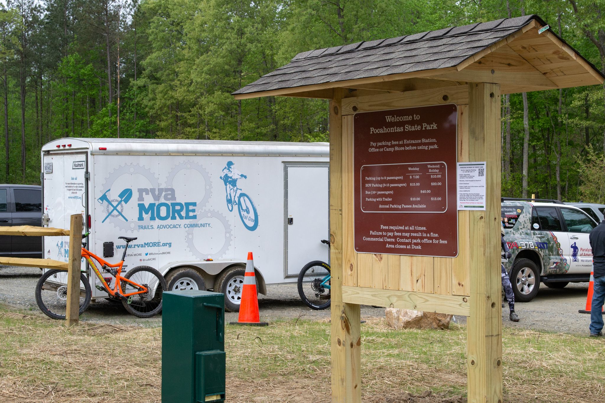Wooden sign, trailer, and mountain bike in a wooded area on a bright day. - Pocahontas State Park – River in Pocahontas State Park loop from Loop Forest Parking Lot