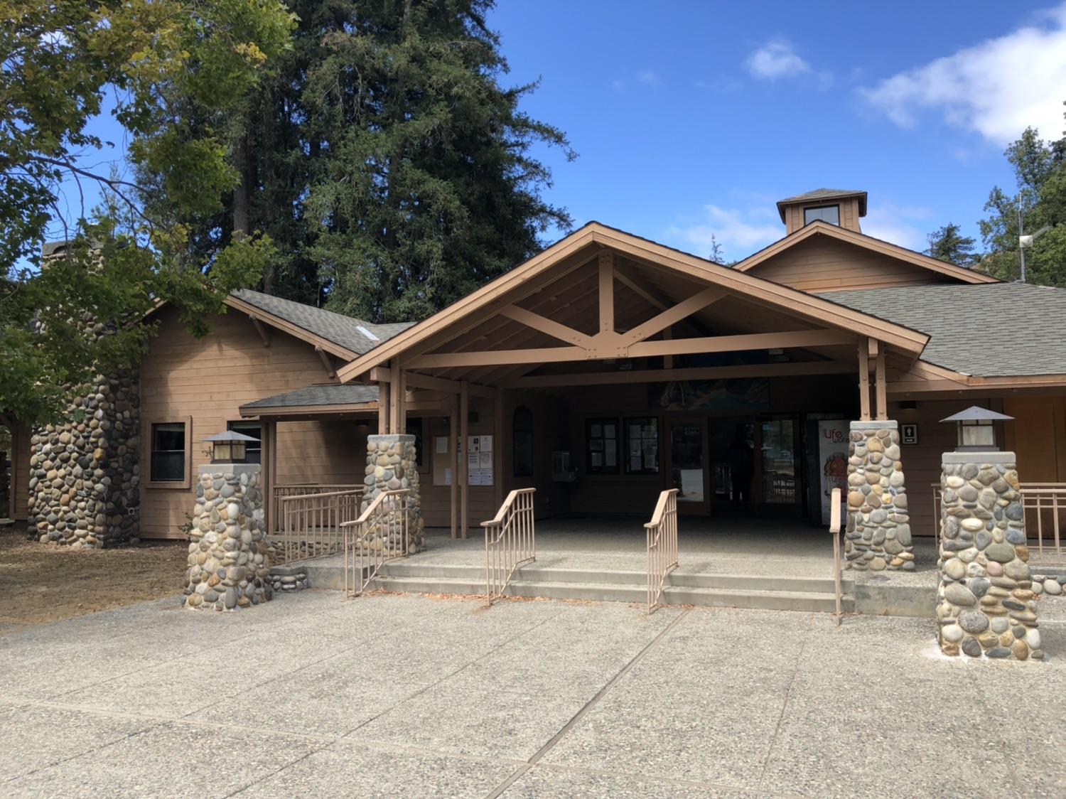 A large wooden building with stone pillars and a covered entrance.