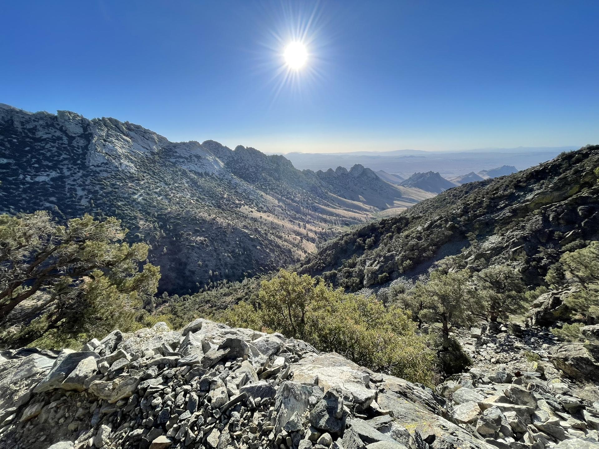 Rugged mountain peaks and a valley bathed in bright sunlight.