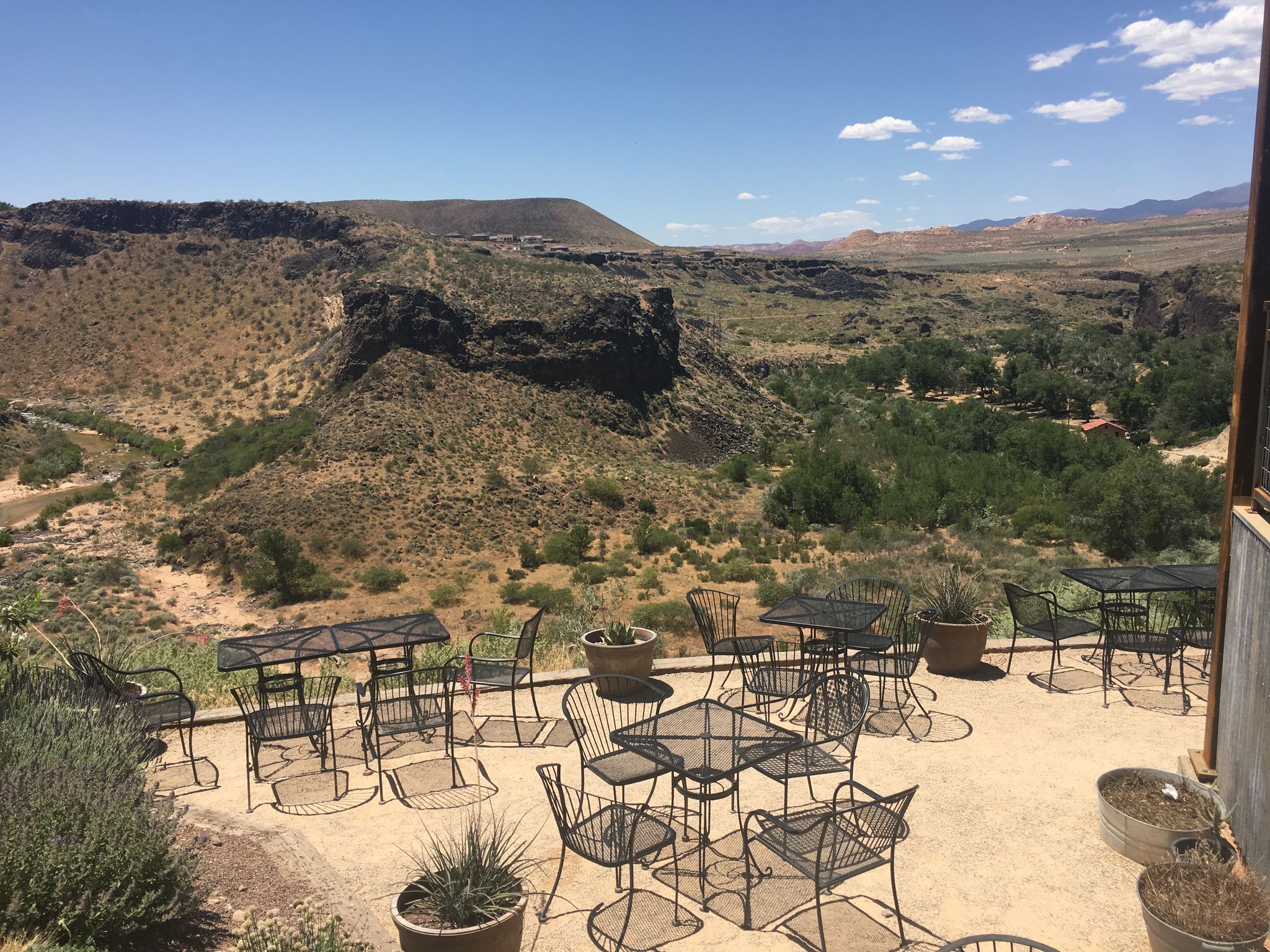 Outdoor patio with metal furniture overlooking a green canyon and arid hills. - Quail Creek State Park & Hurricane, Utah loop