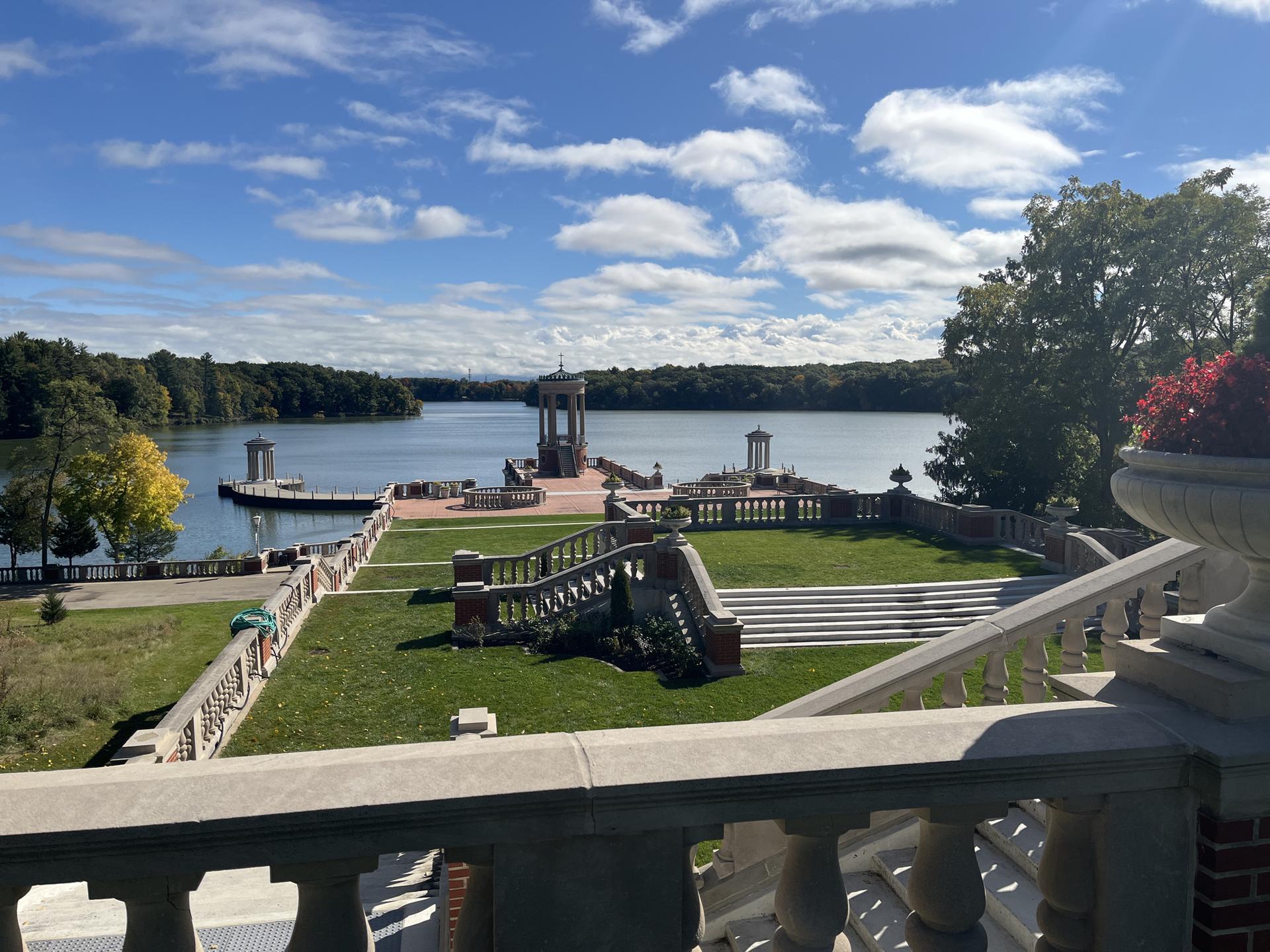 Grand lakeside terrace with multiple gazebos under a bright blue sky.