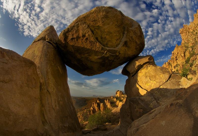 Dramatic balanced rock formation against a cloudy, golden hour sky.