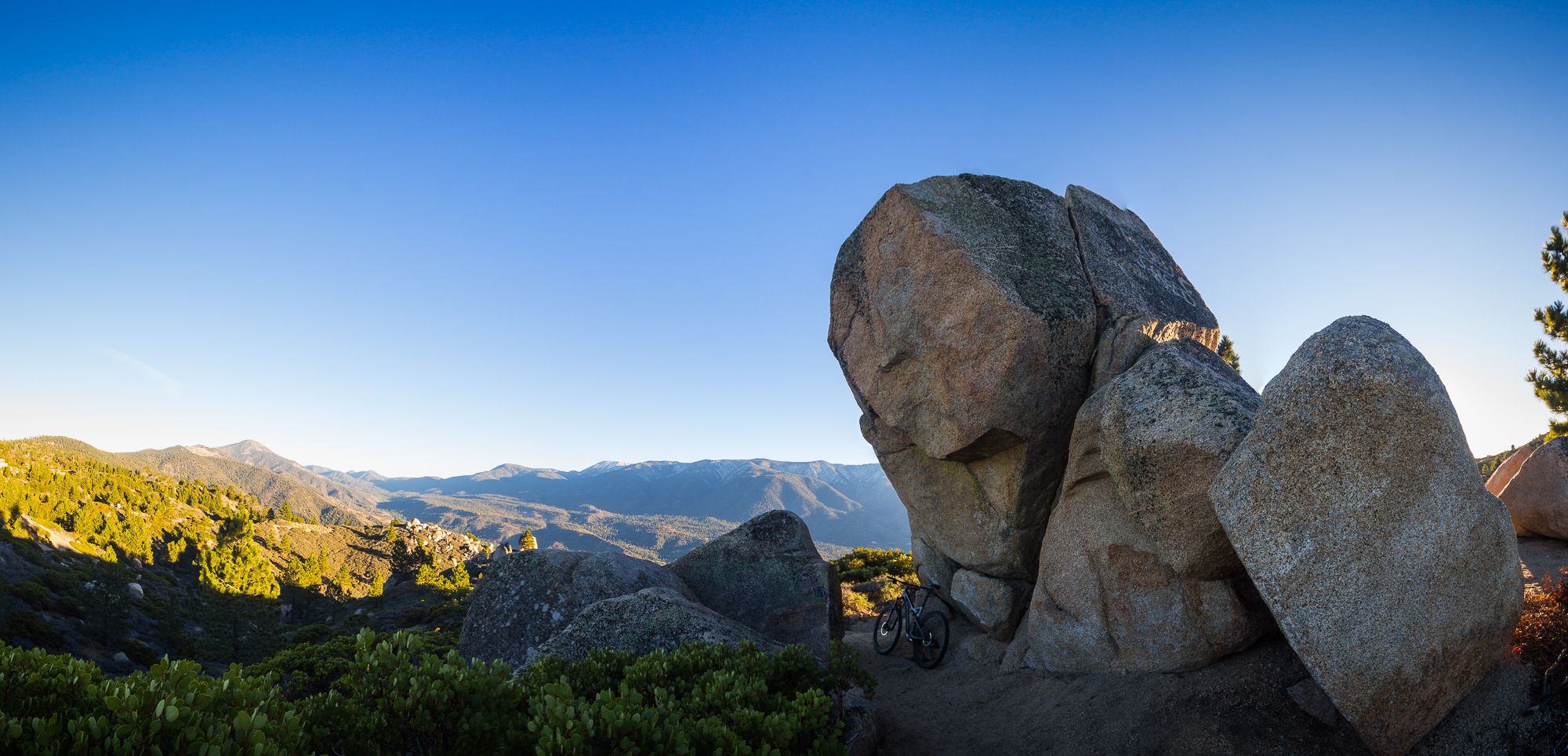 Large boulders on a mountain ridge overlooking a vast, sunlit landscape. - Skyline Trail Loop