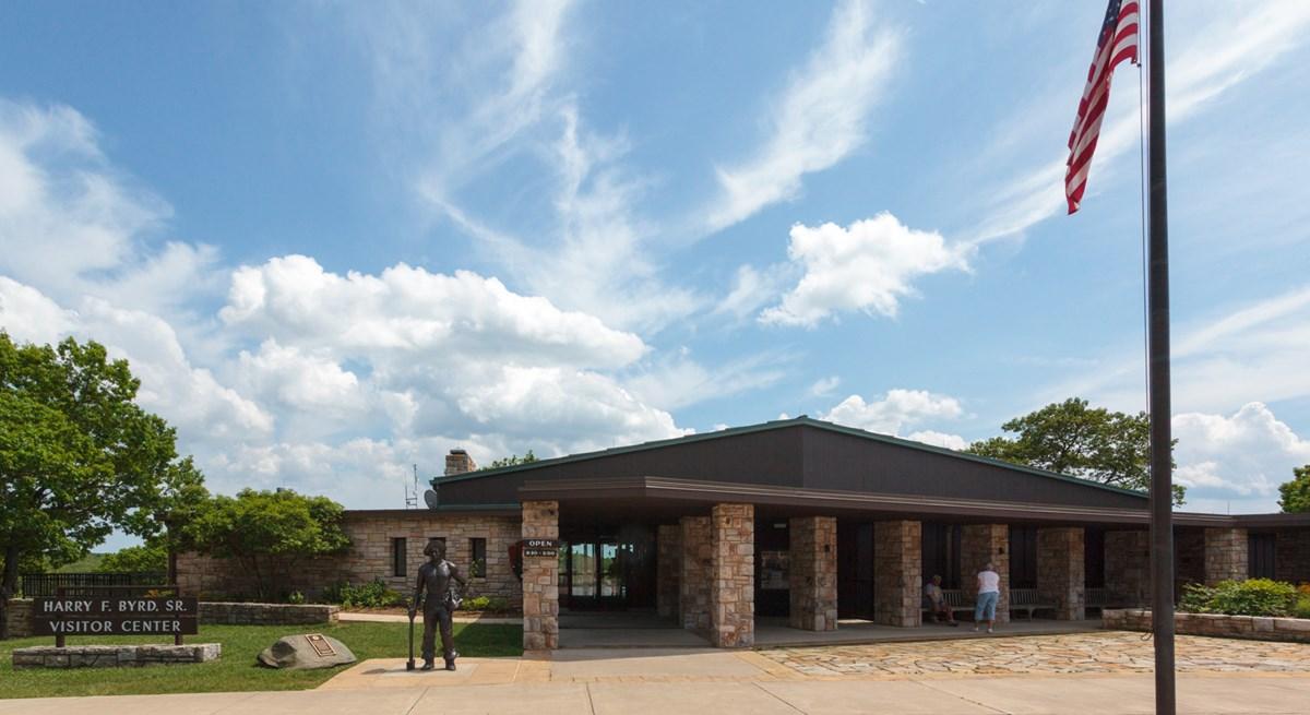 Visitor center building under a blue sky with an American flag.