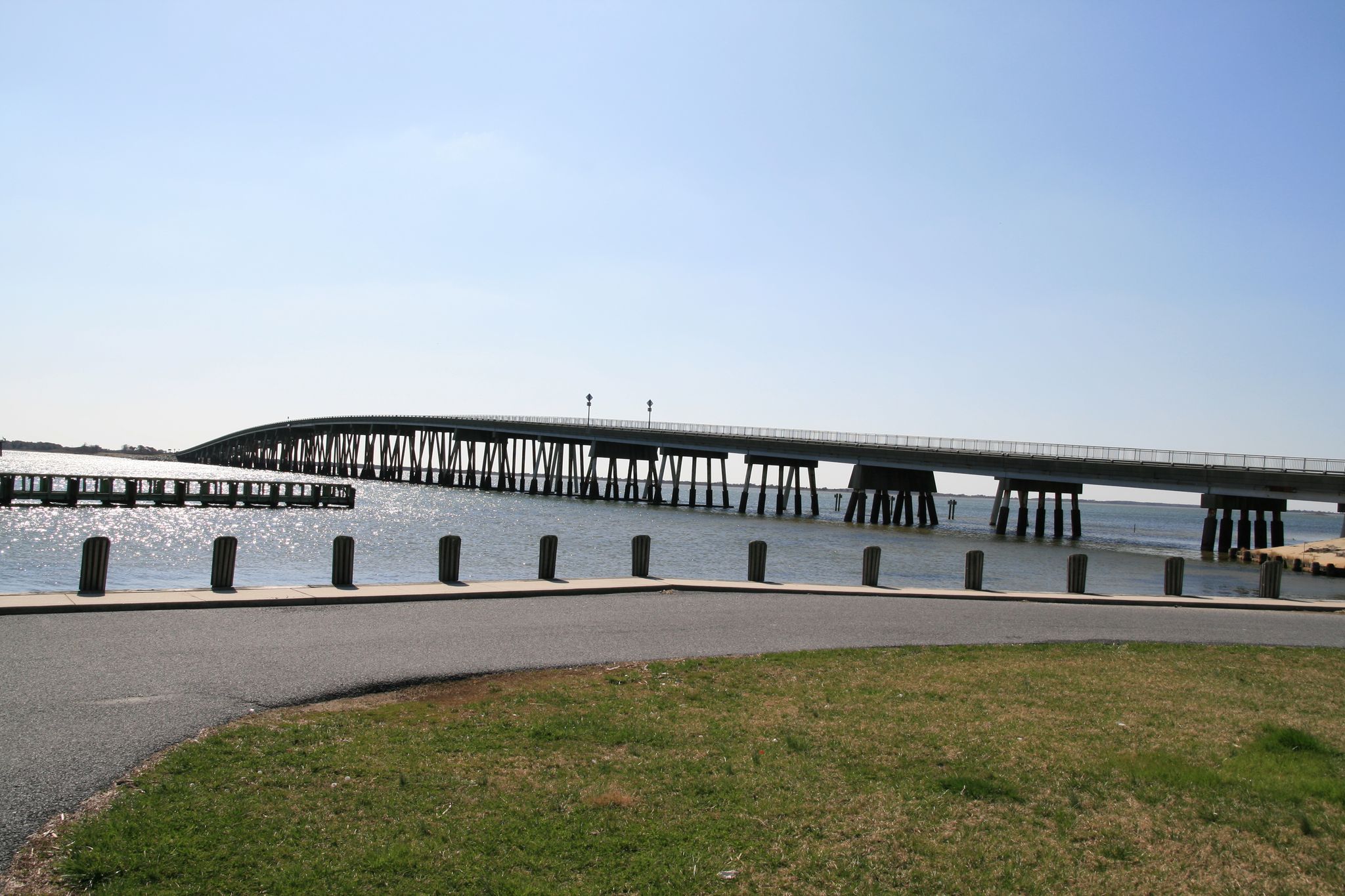 A long bridge spans calm water under a clear blue sky. - Verrazano Bridge – Relaxation on the beach loop from Berlin
