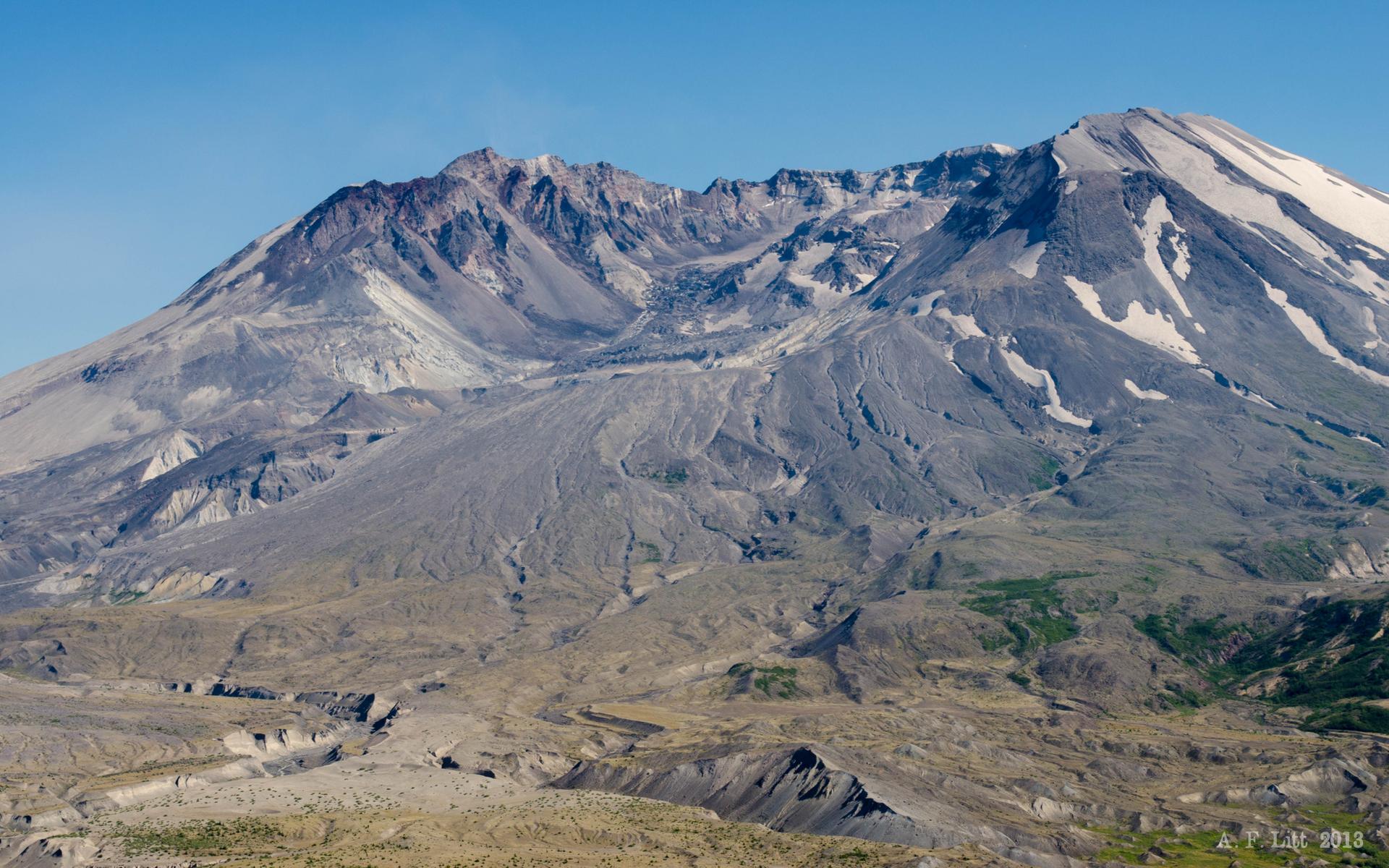Close-up of a rugged, snow-dusted mountain with a rocky crater.