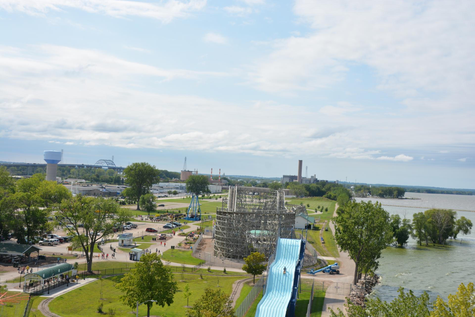 Amusement park with a large water slide next to a wide river.