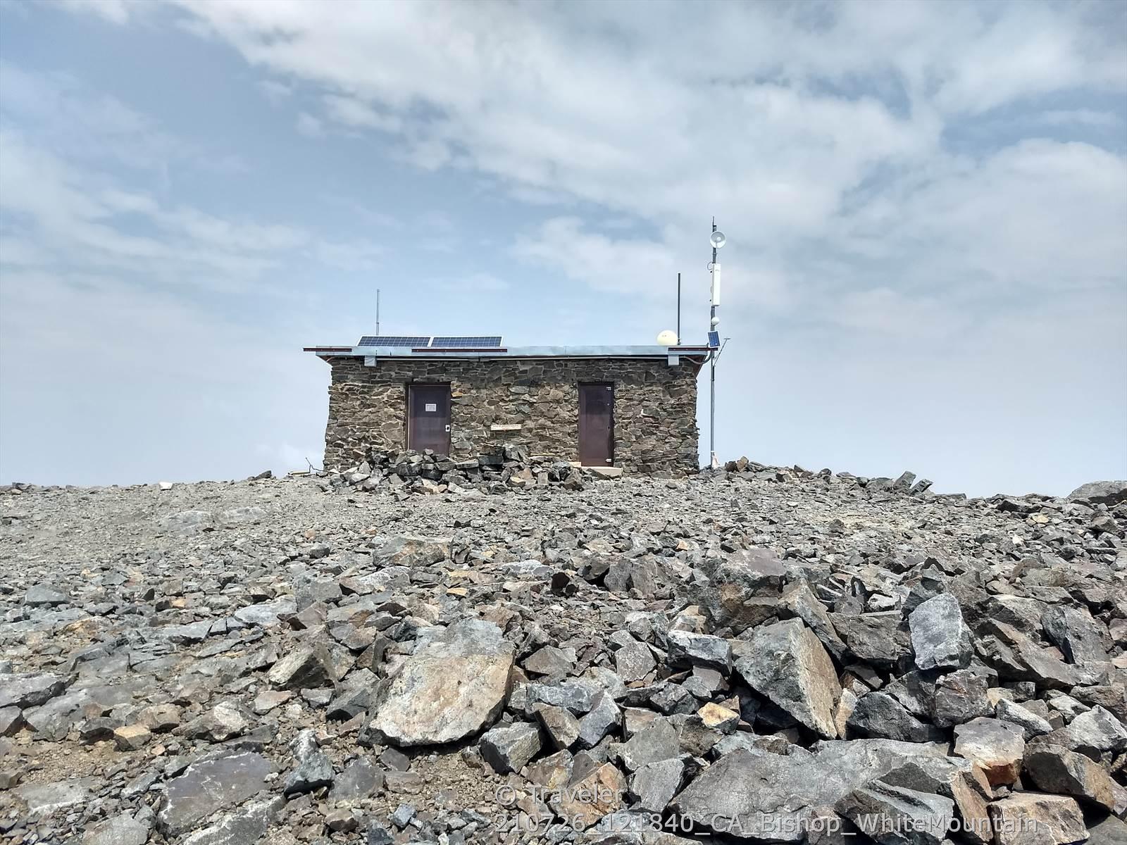 Stone building on a rocky, barren hilltop under a cloudy sky.