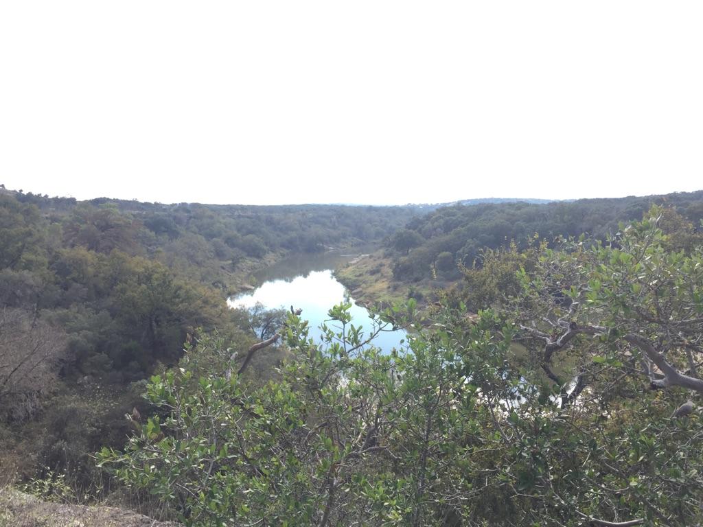 Overhead view of a river flowing through a densely wooded valley.