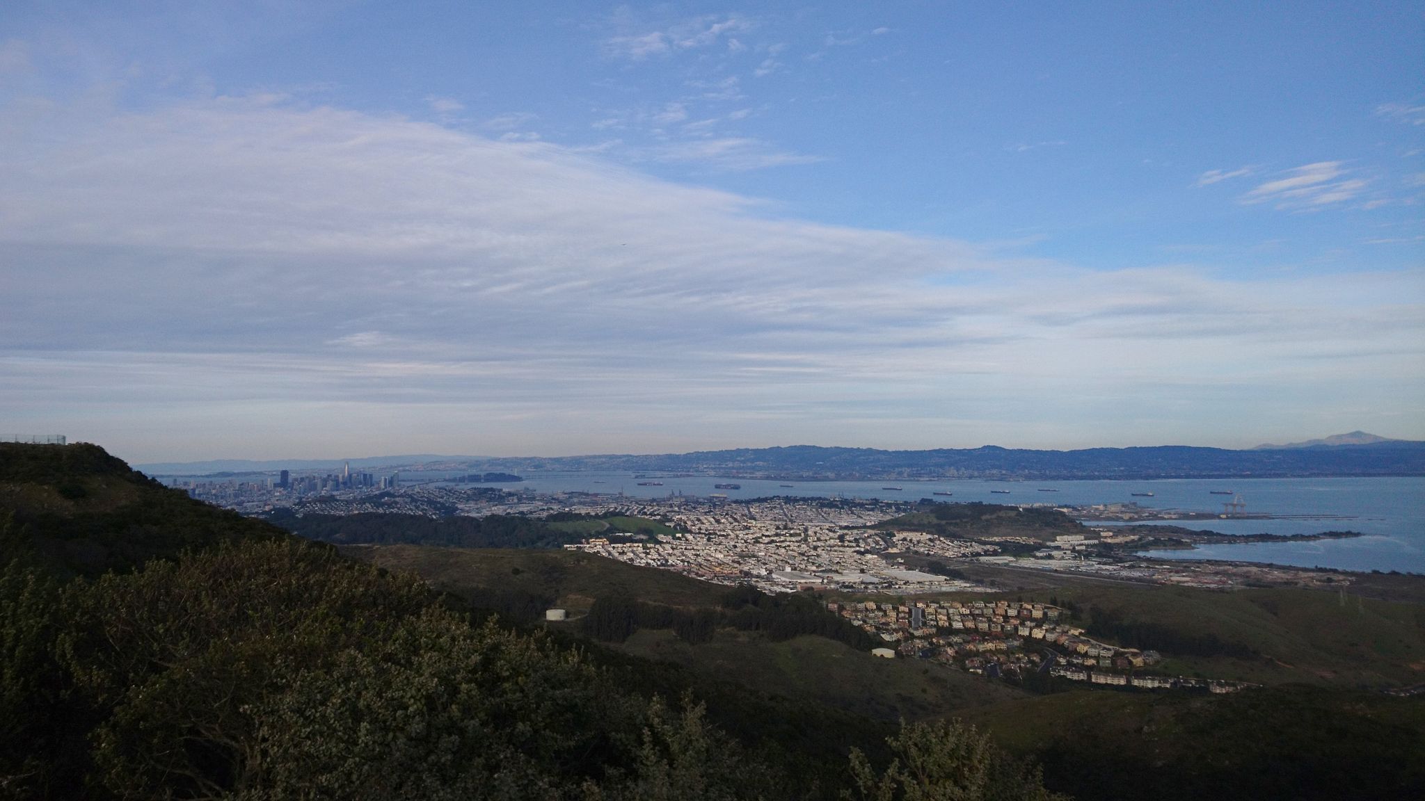Panoramic view of a city and bay under a cloudy sky. - San Bruno Mountain Summit Loop