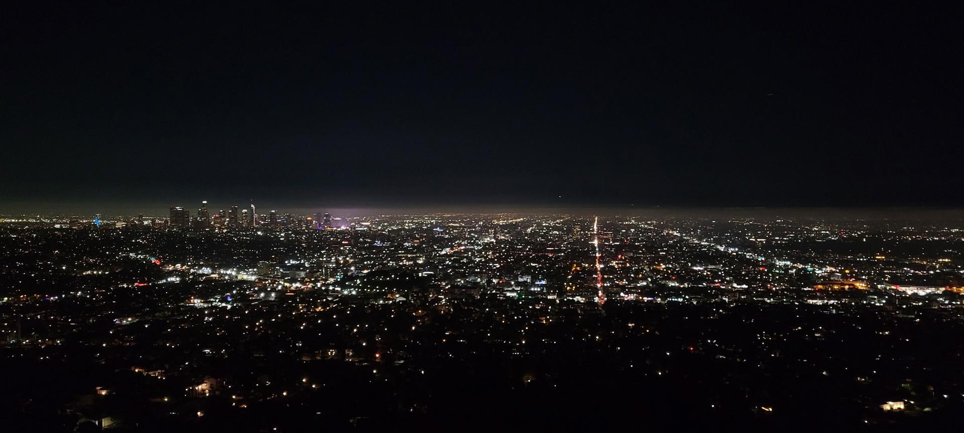 Vast city lights glowing brightly at night under a dark sky.