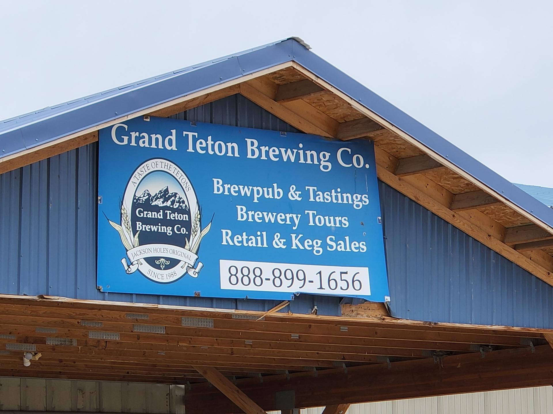 A blue sign for a brewing company on the side of a building.