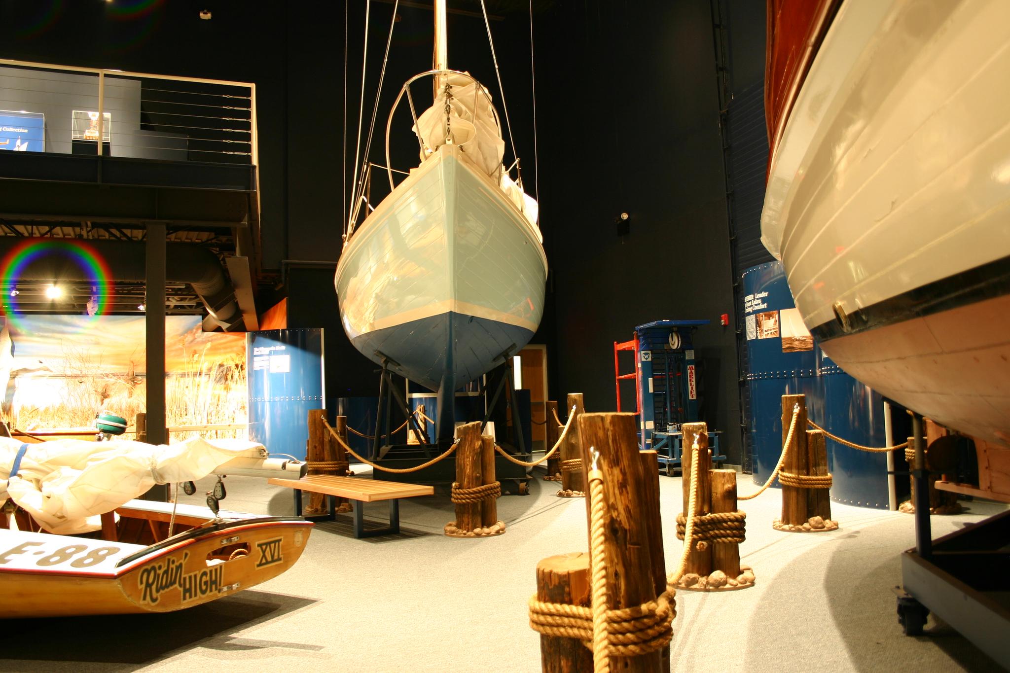 Indoor museum display with a light blue boat hanging from the ceiling.