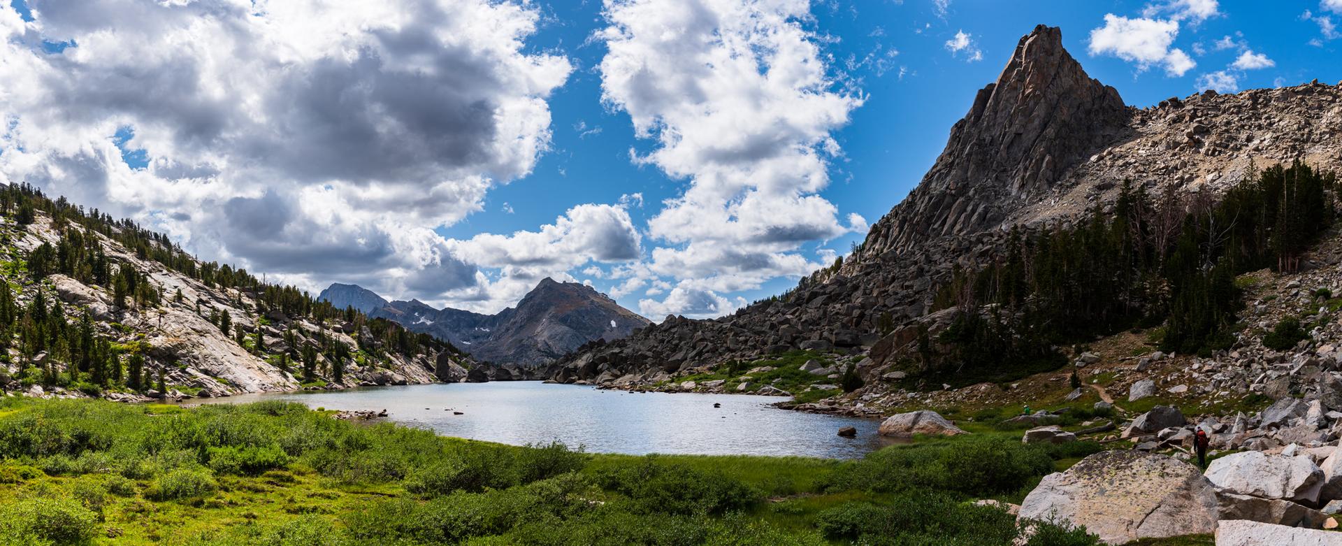 Panoramic view of a tranquil lake nestled between towering, rocky mountains.