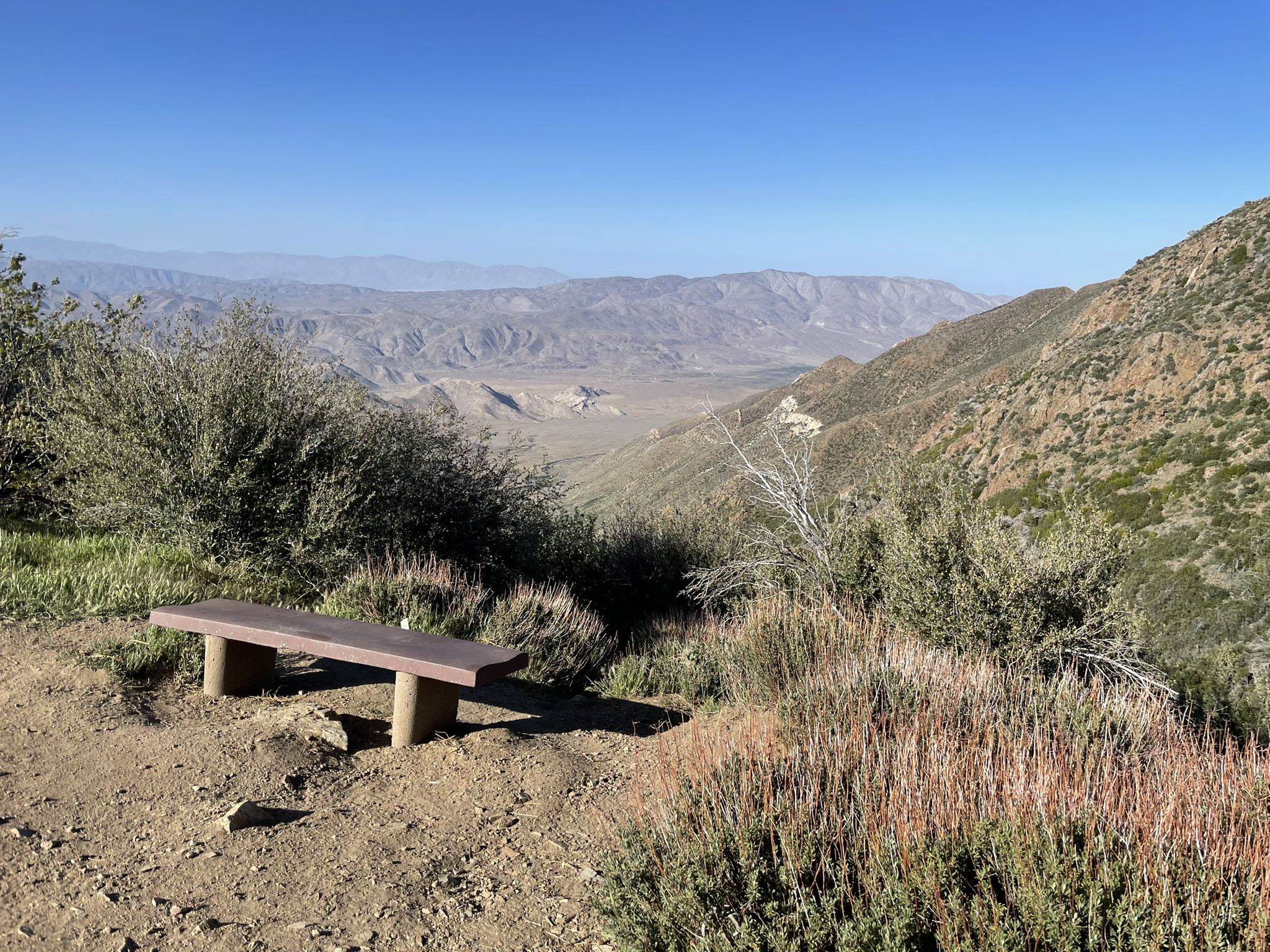 Wooden bench overlooking a vast mountain valley under clear blue sky. - Laguna Mountain Ridge via the PCT