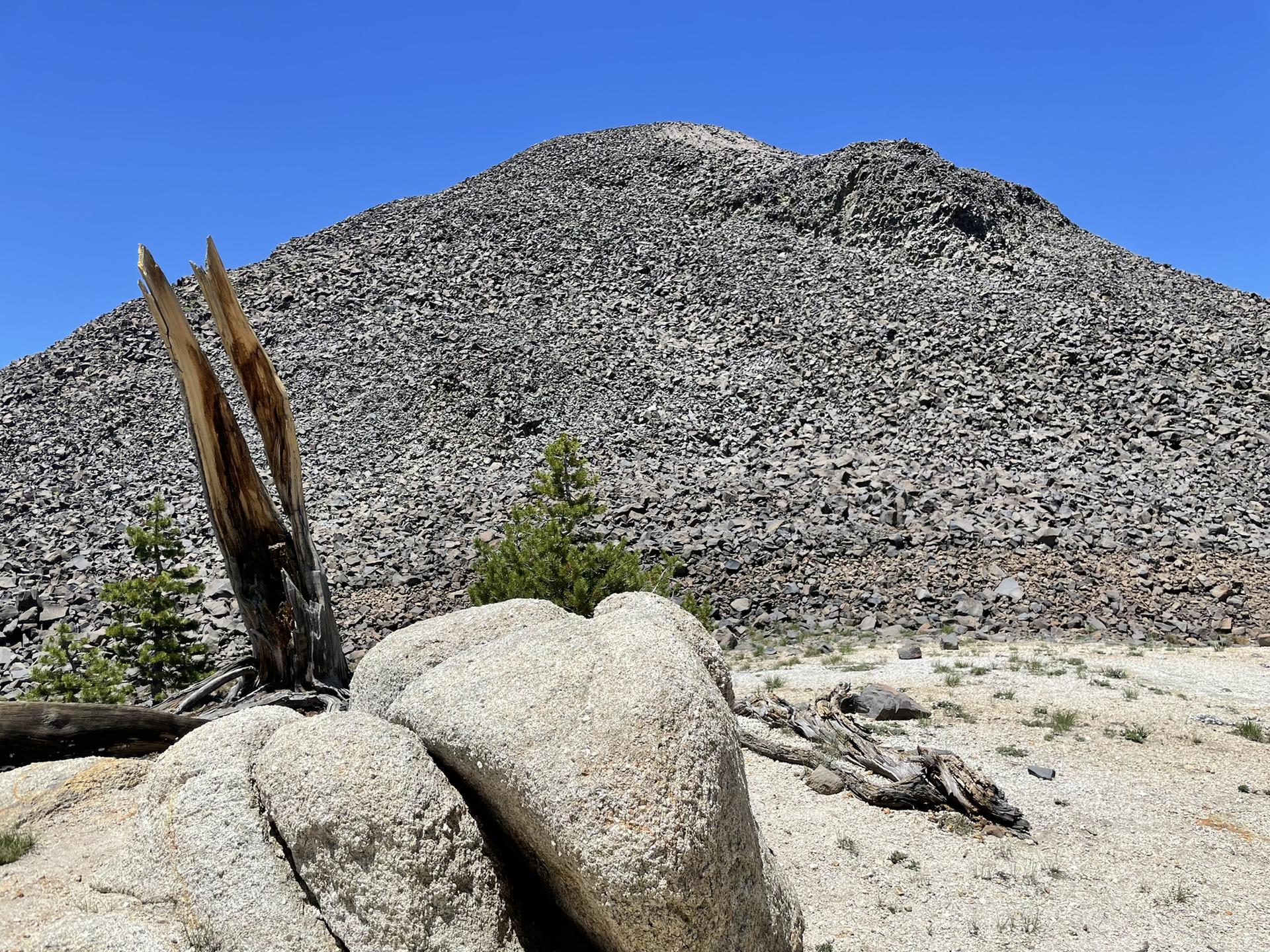 A massive, rocky mountain peak dominates under a clear blue sky.