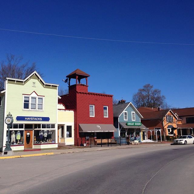 Colorful storefronts line a street under a clear blue sky.