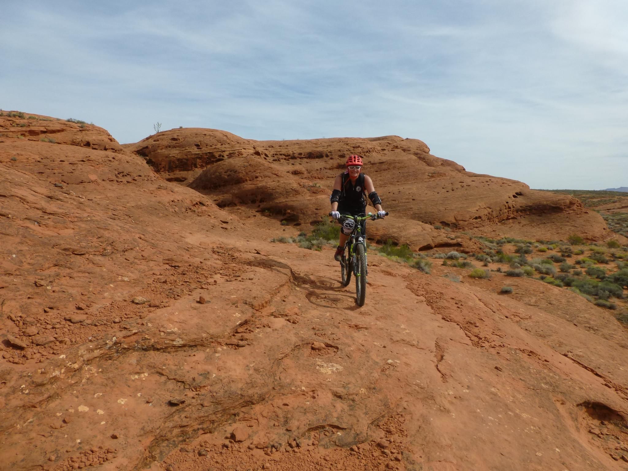 Male mountain biker on a red rock trail under a bright sky. - Prospector and Church Rocks Trail